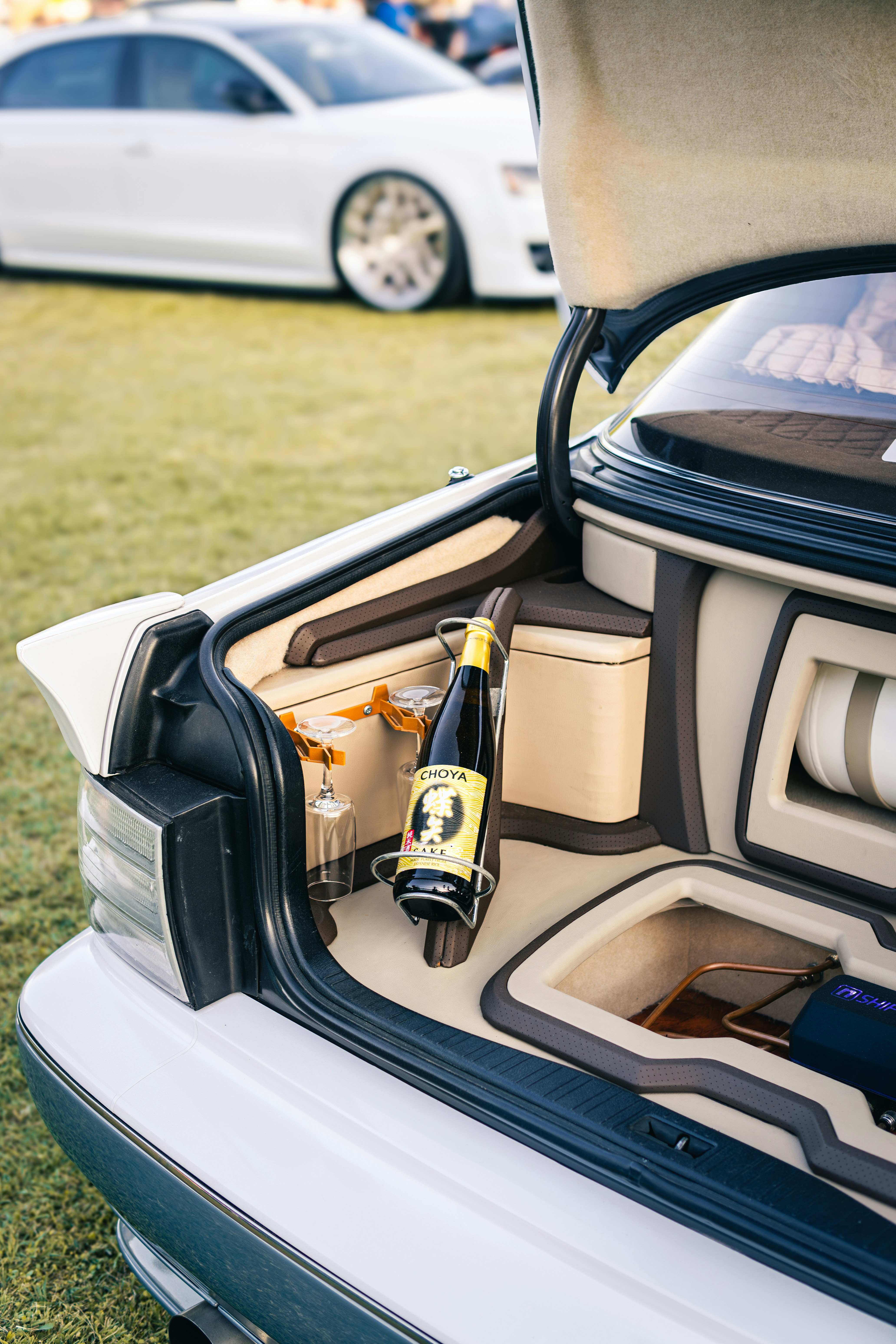 Bottle of champagne and glasses in car trunk