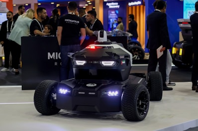 A futuristic security robot with flashing lights on display.