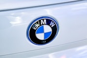 Close-up of a white car's BMW emblem