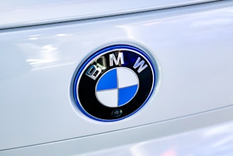 Close-up of a white car's BMW emblem