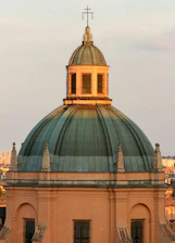 Green dome of a historic building at sunset