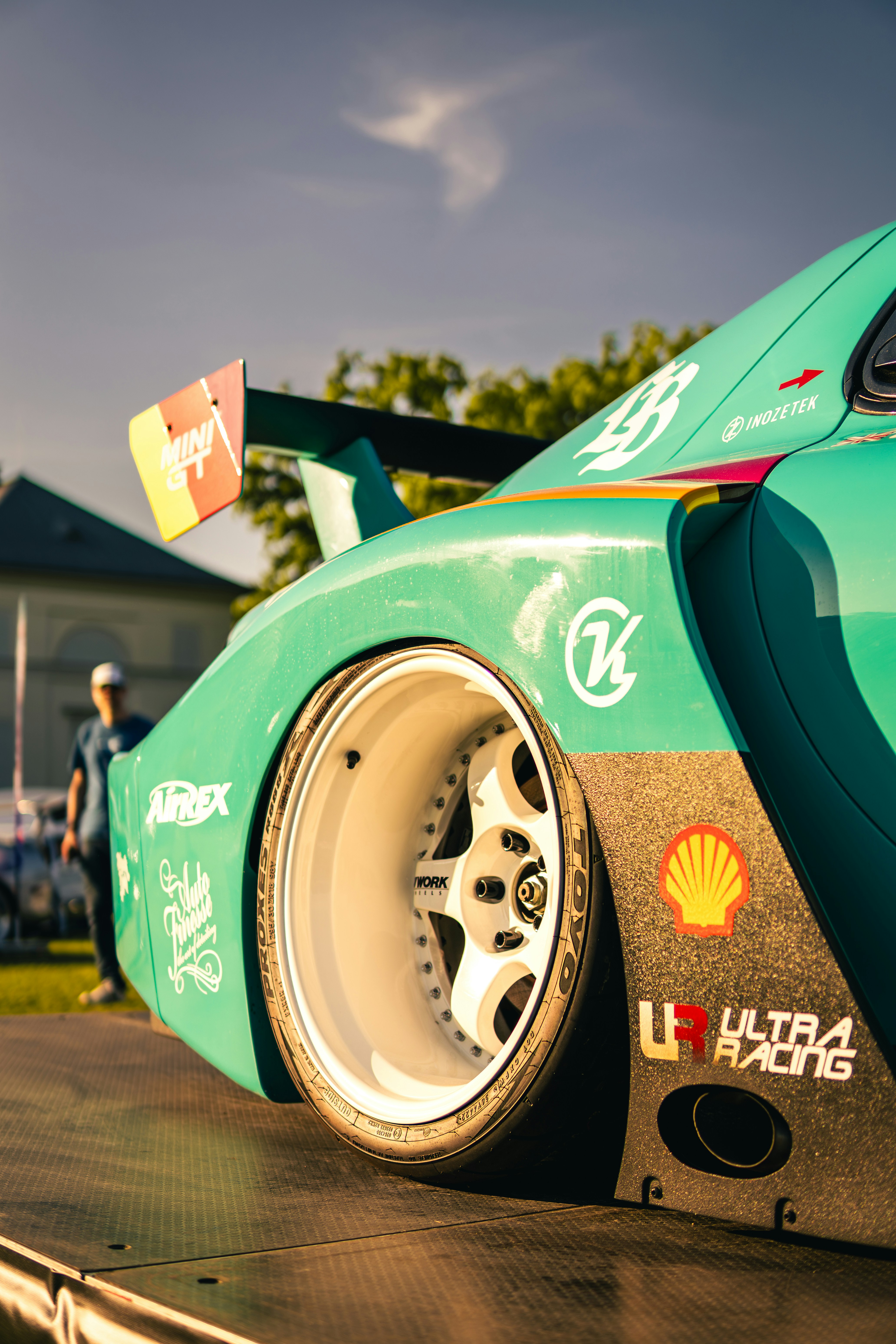 Modified teal sports car with custom wheels