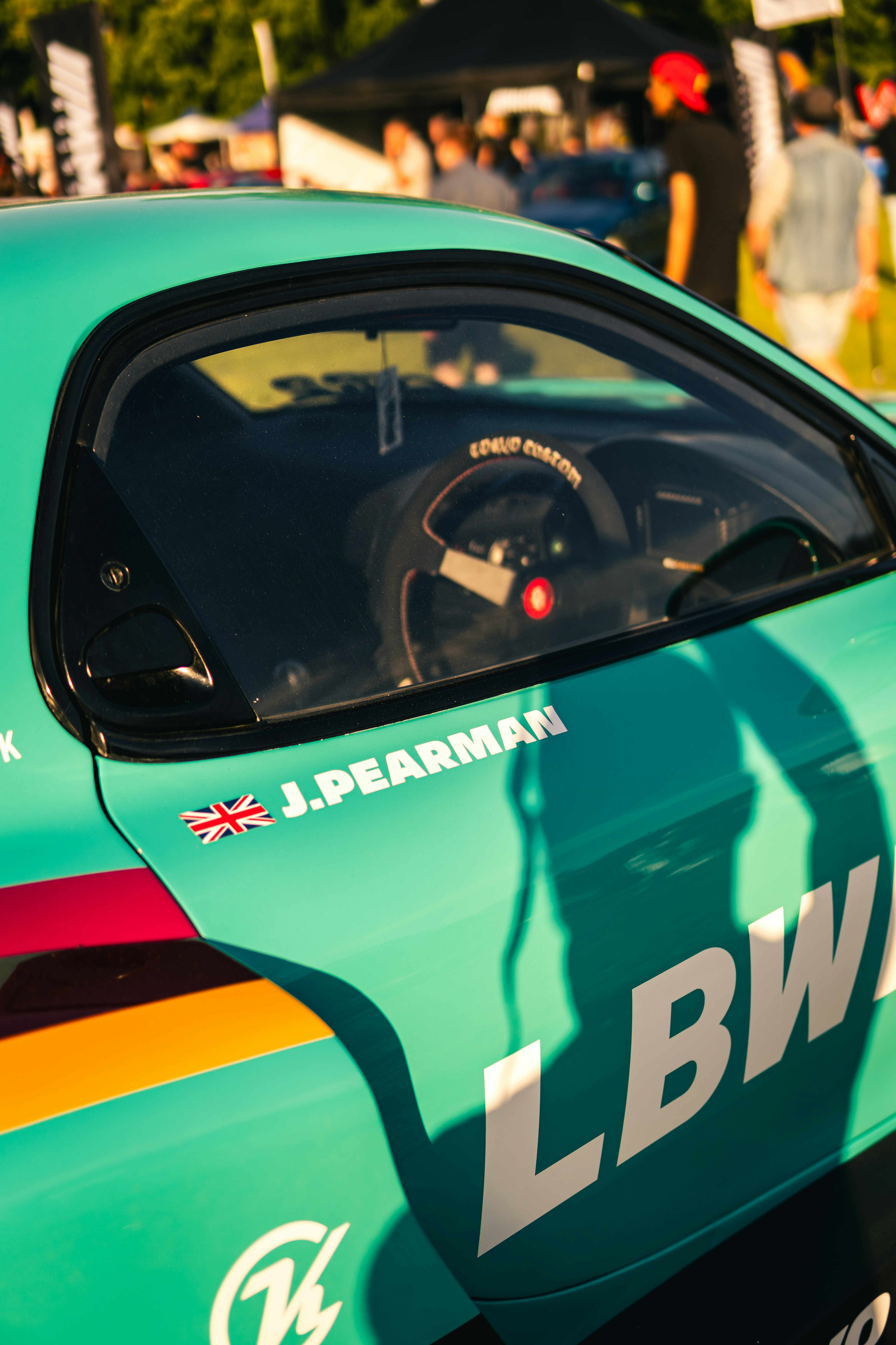 レーシングデカールとステアリングホイールが付いたティールカー