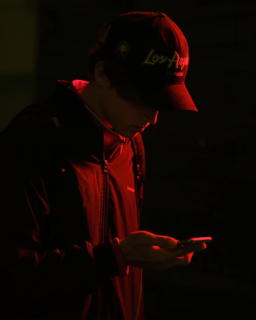 Person in a baseball cap looking at a phone.