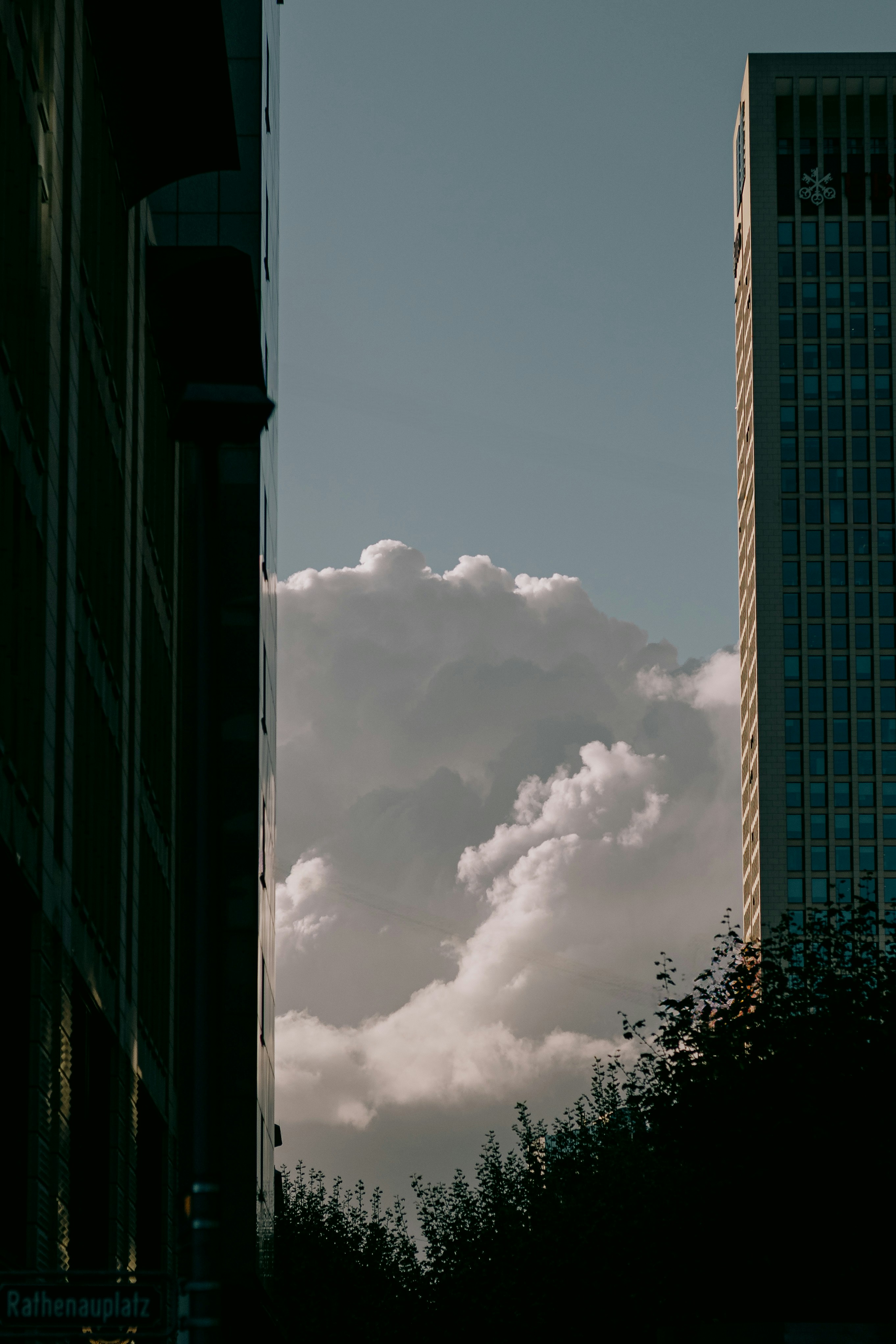 Tall buildings framing dramatic clouds in the sky