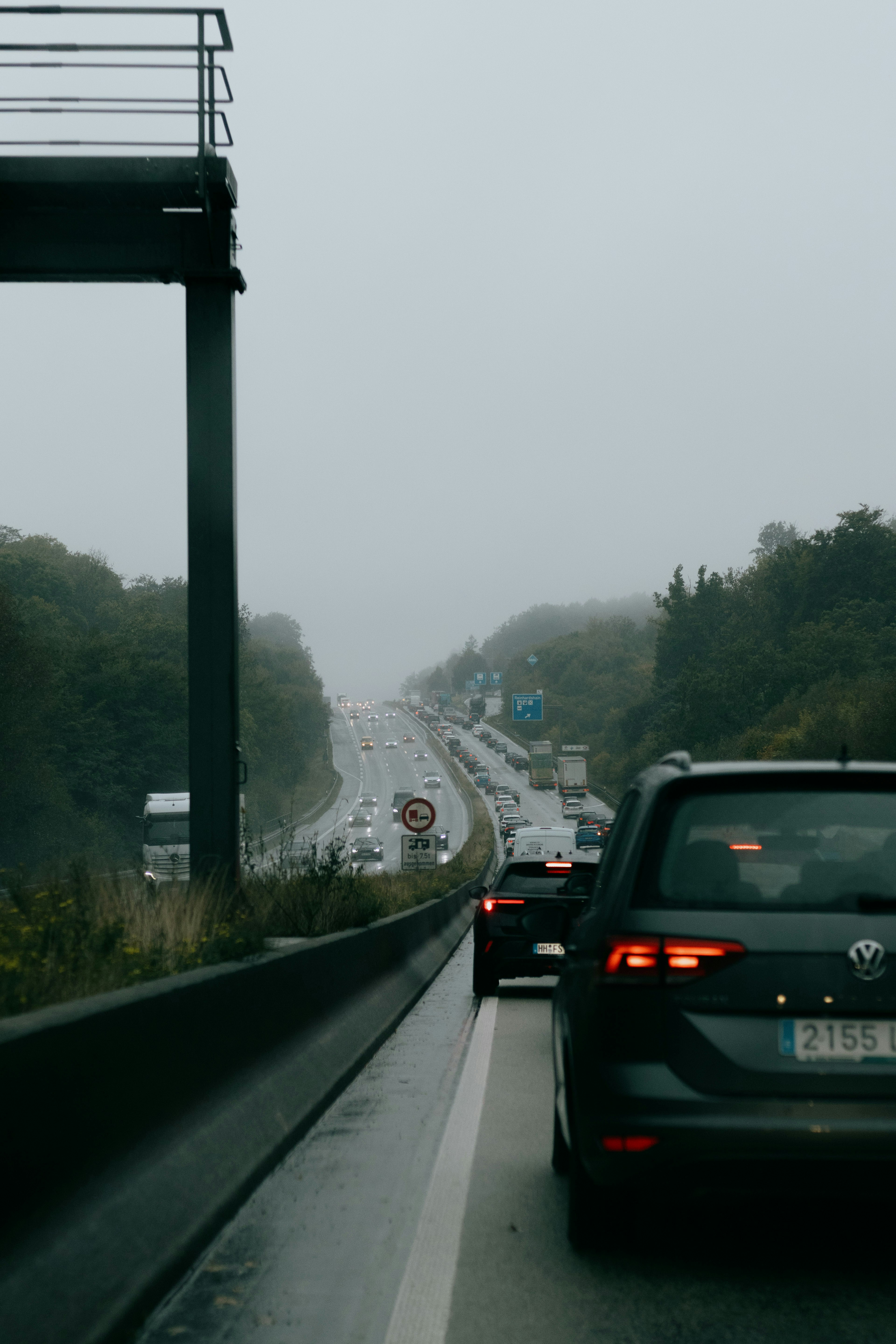 Cars stuck in traffic on a wet highway.
