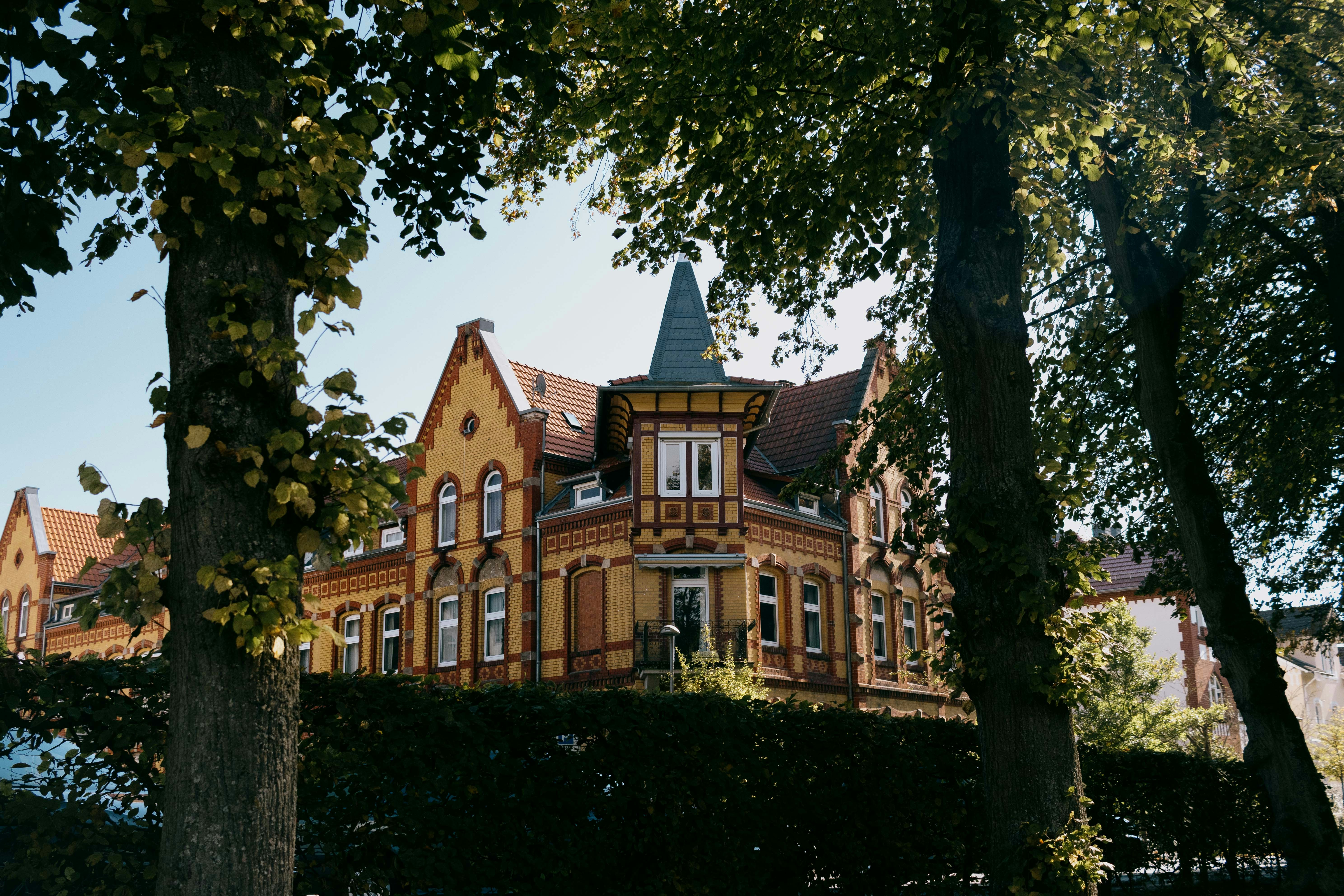 Ornate yellow house with a pointed blue roof.
