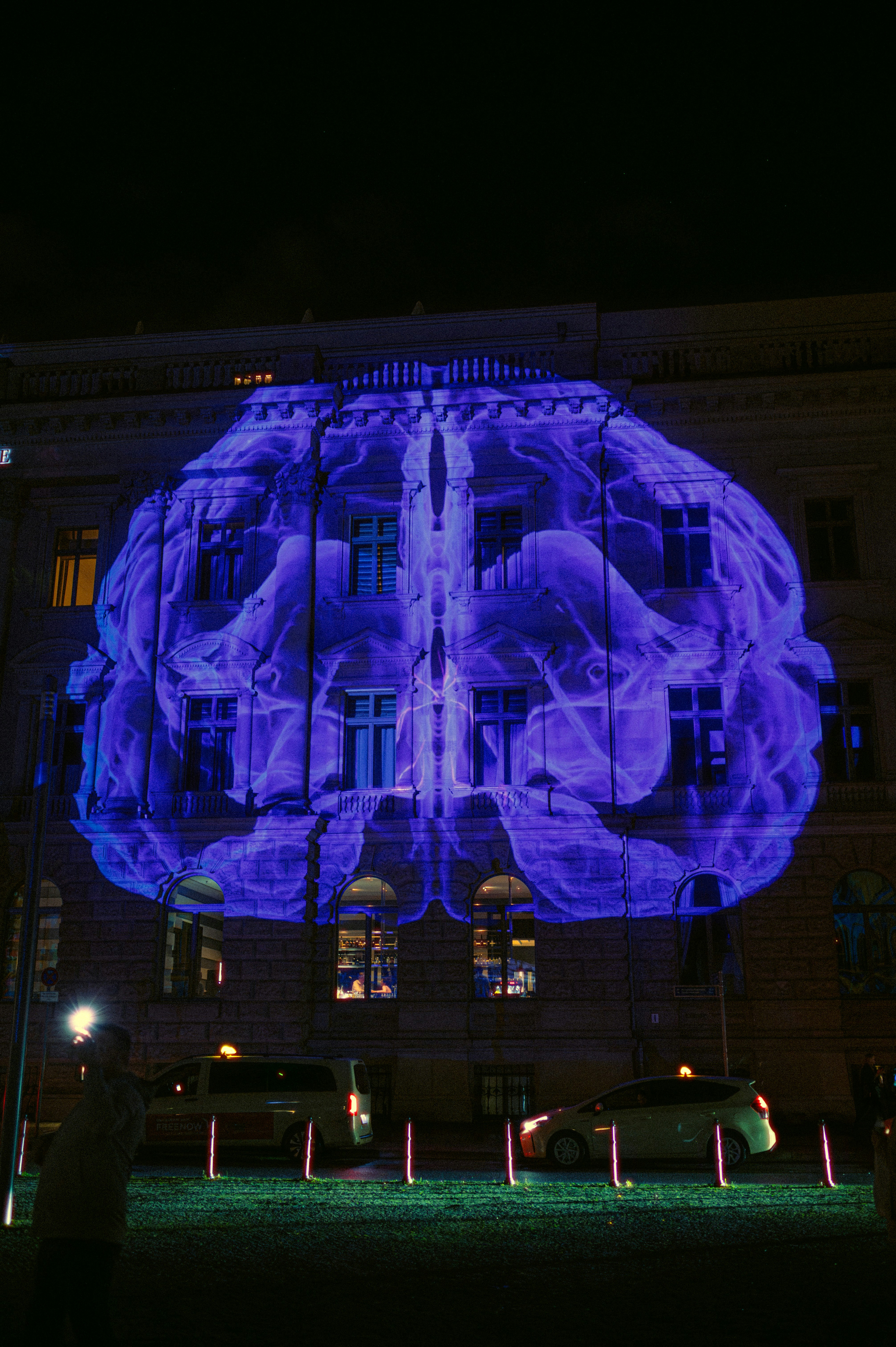 Building facade illuminated with a giant blue brain projection