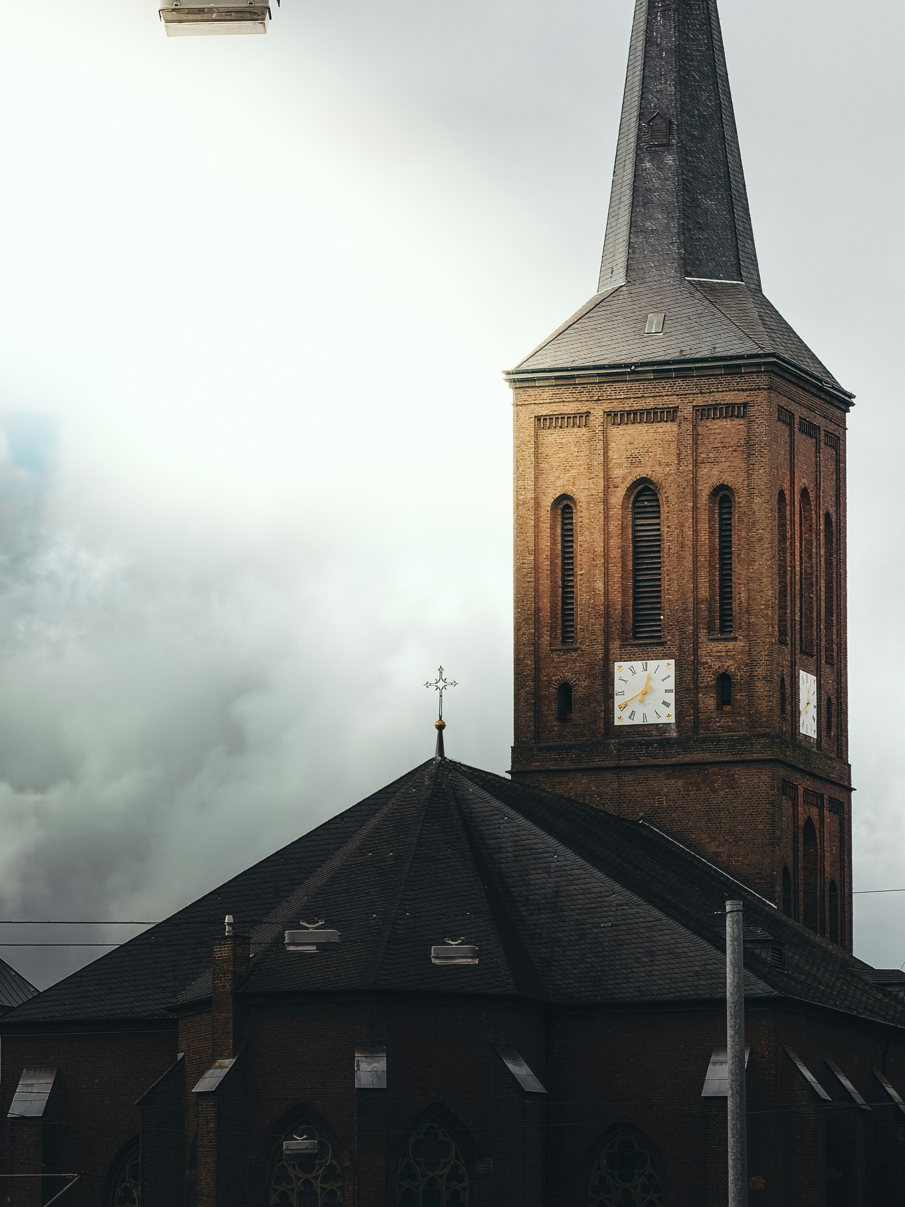 Brick church tower with a steeple against sky