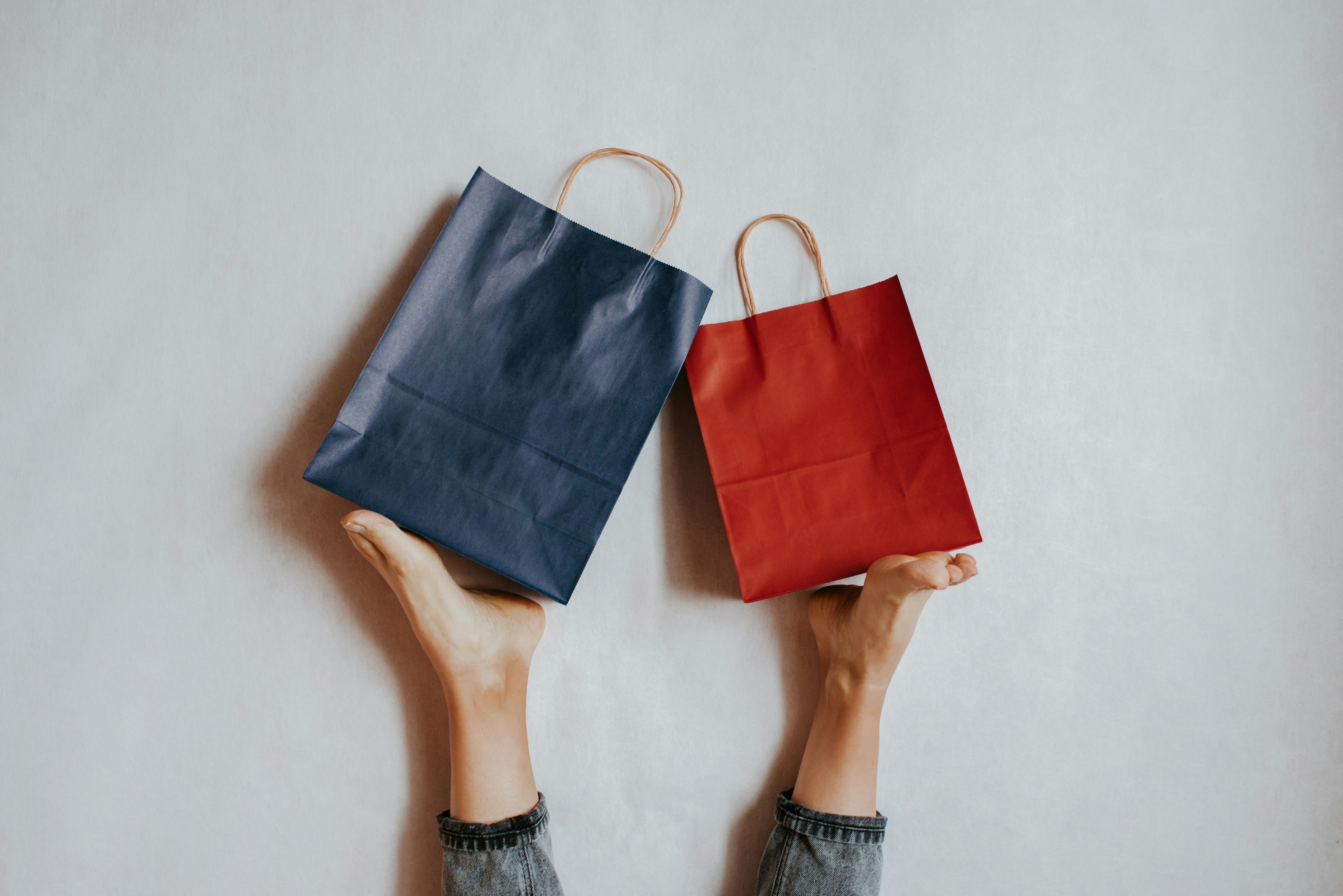 Two hands holding shopping bags