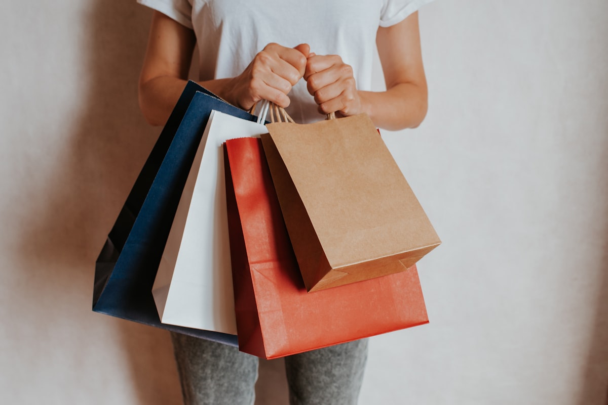 Person holding colorful shopping bags representing consumer spending