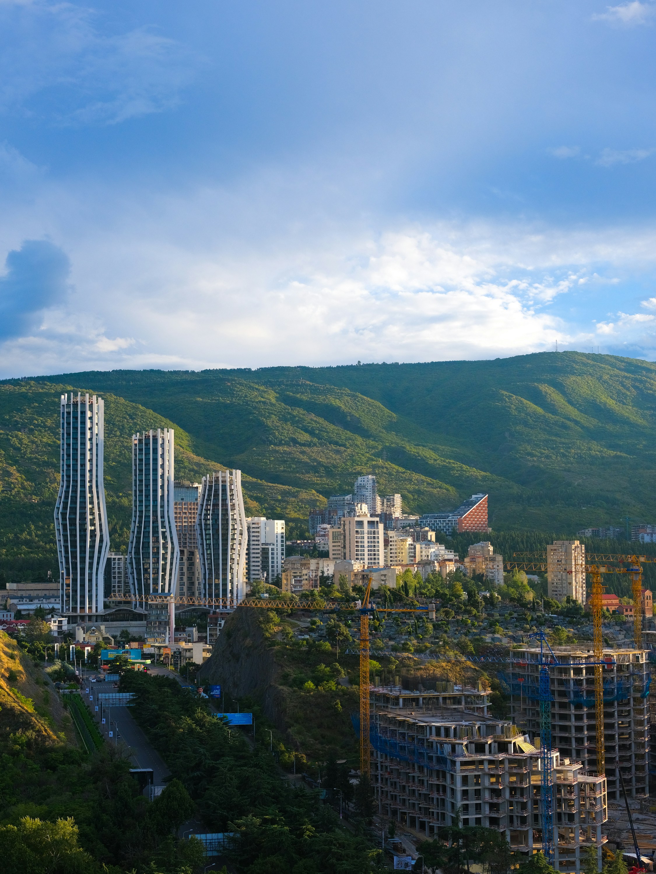 Modern city skyline nestled against green hillsides.