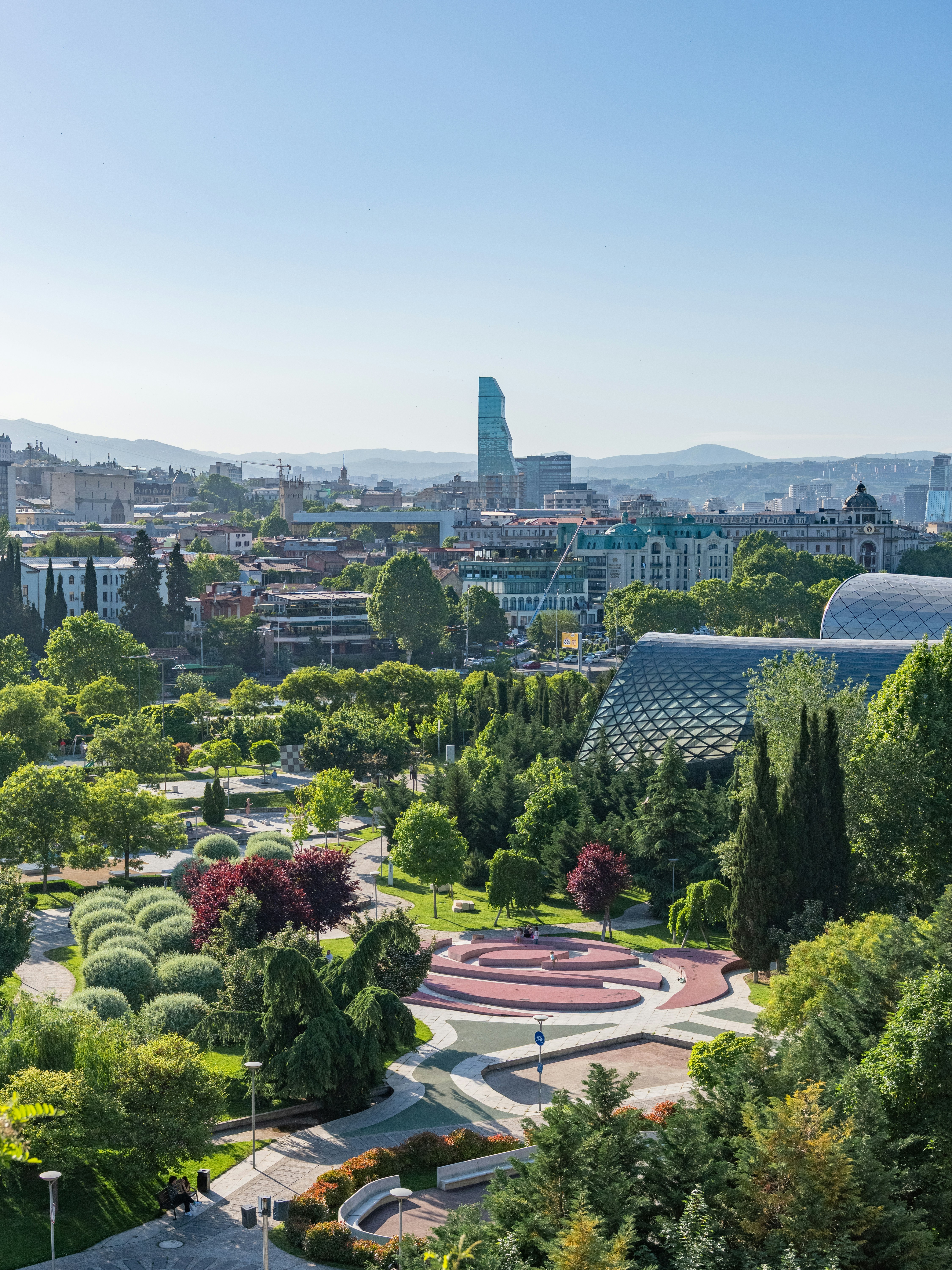 Green park with modern buildings and cityscape background.