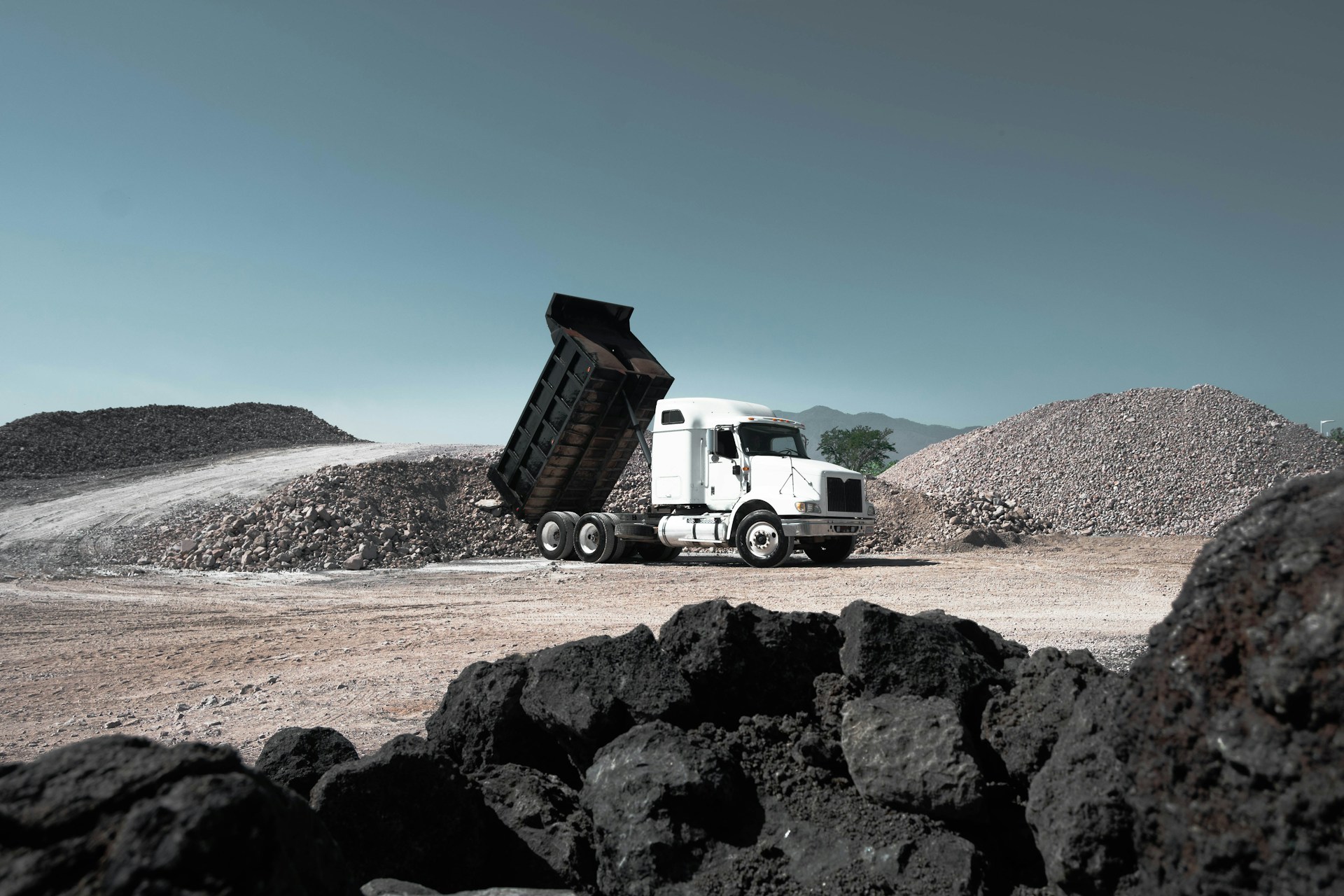 White dump truck unloading rocks at a quarry