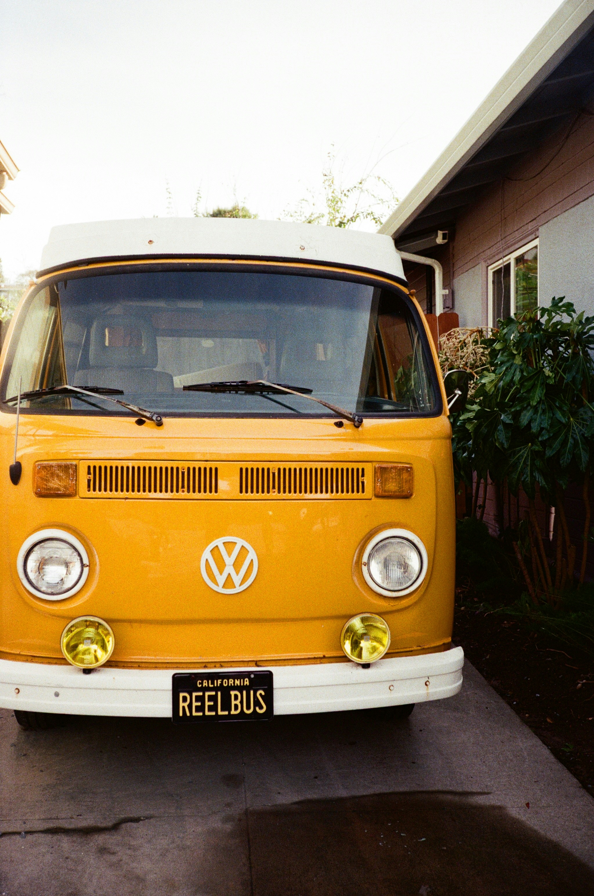 Yellow vintage volkswagen bus parked outside house