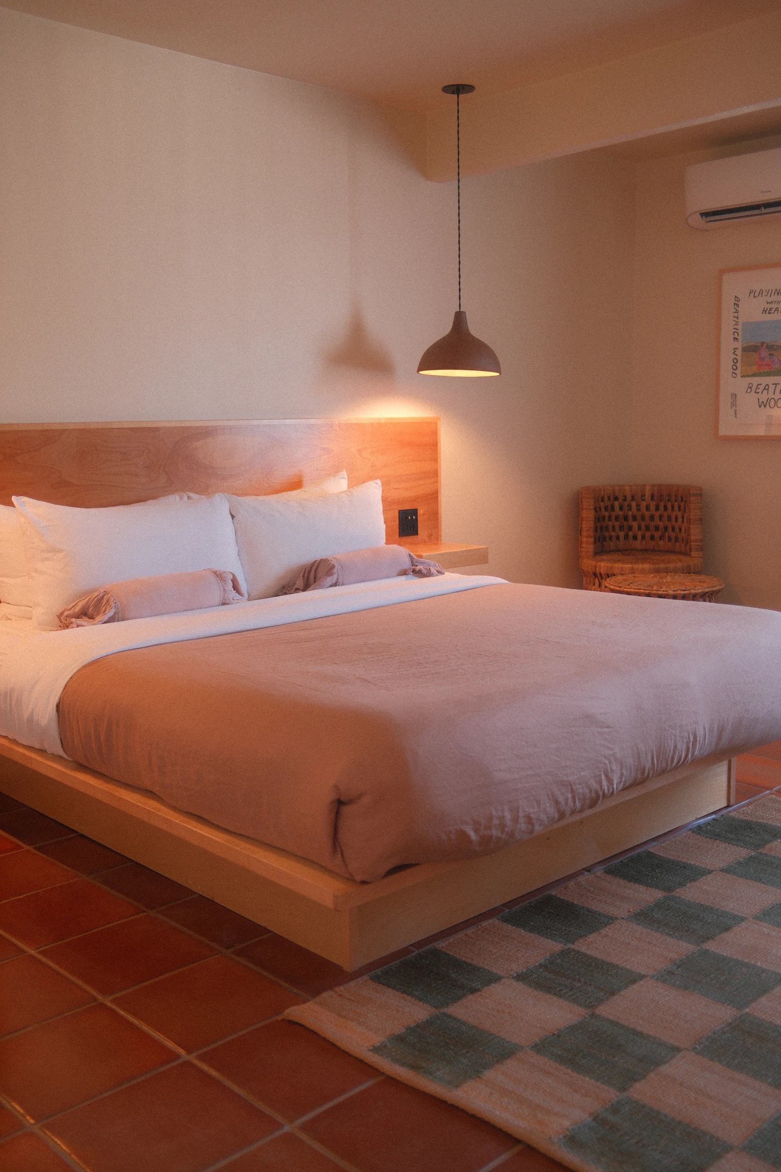 Warmly lit bedroom with a large made bed