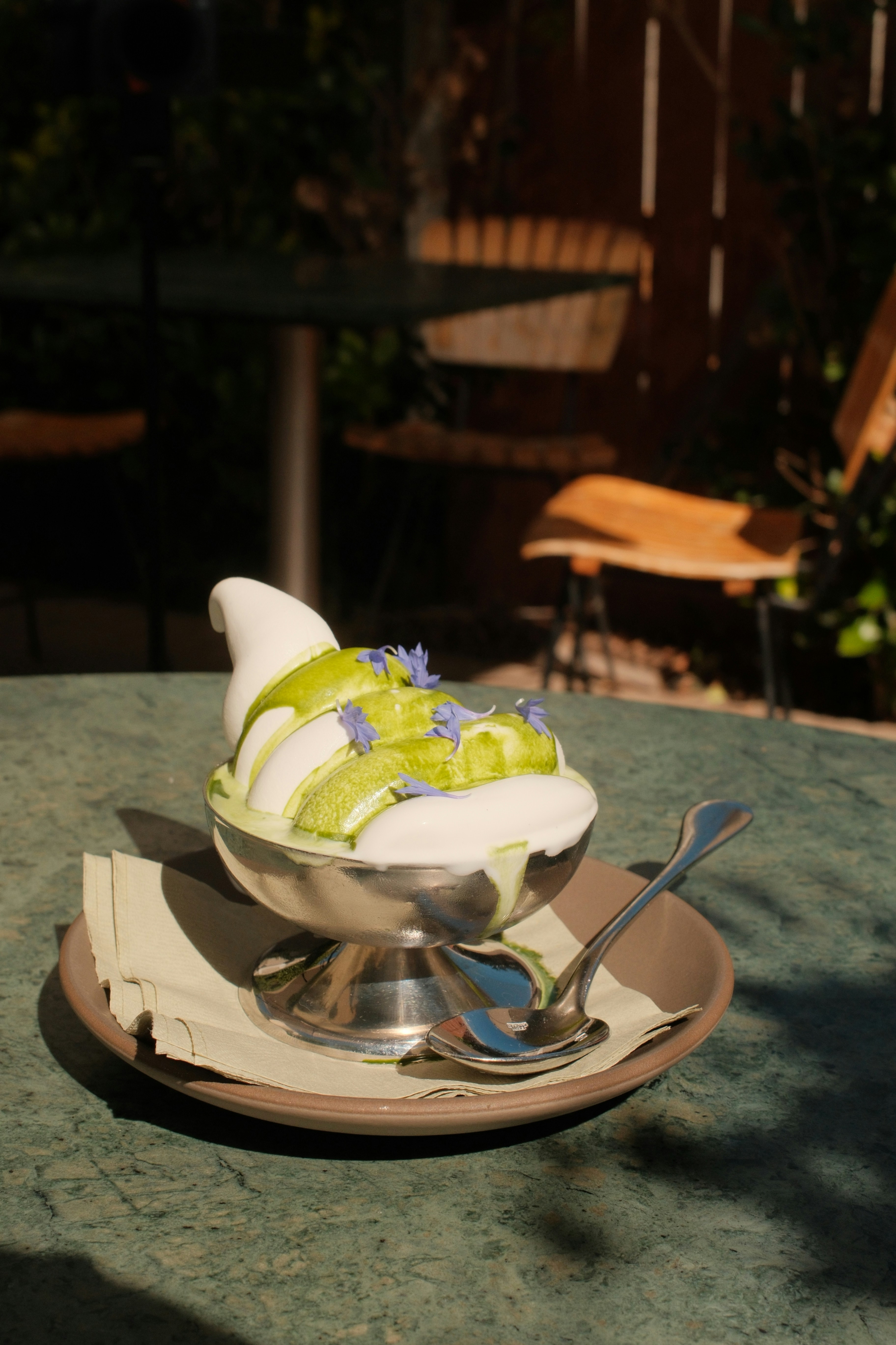 Soft serve ice cream with green drizzle and flowers