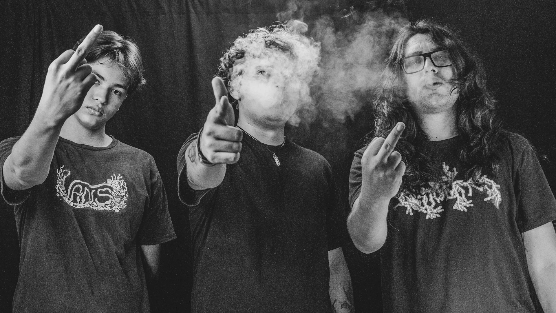 Three people smoking and gesturing at the camera.