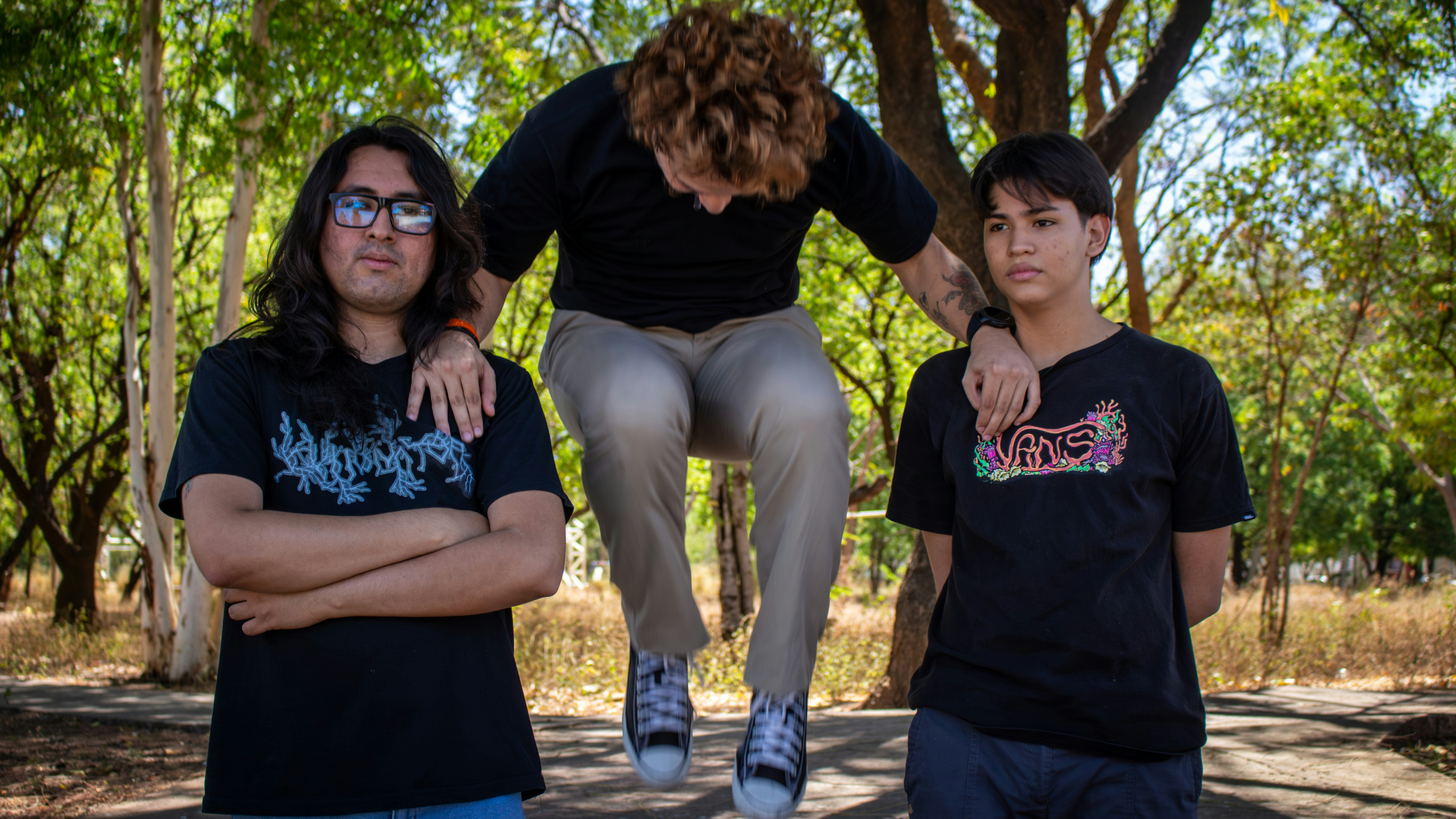 Trois amis posant à l’extérieur avec un saut