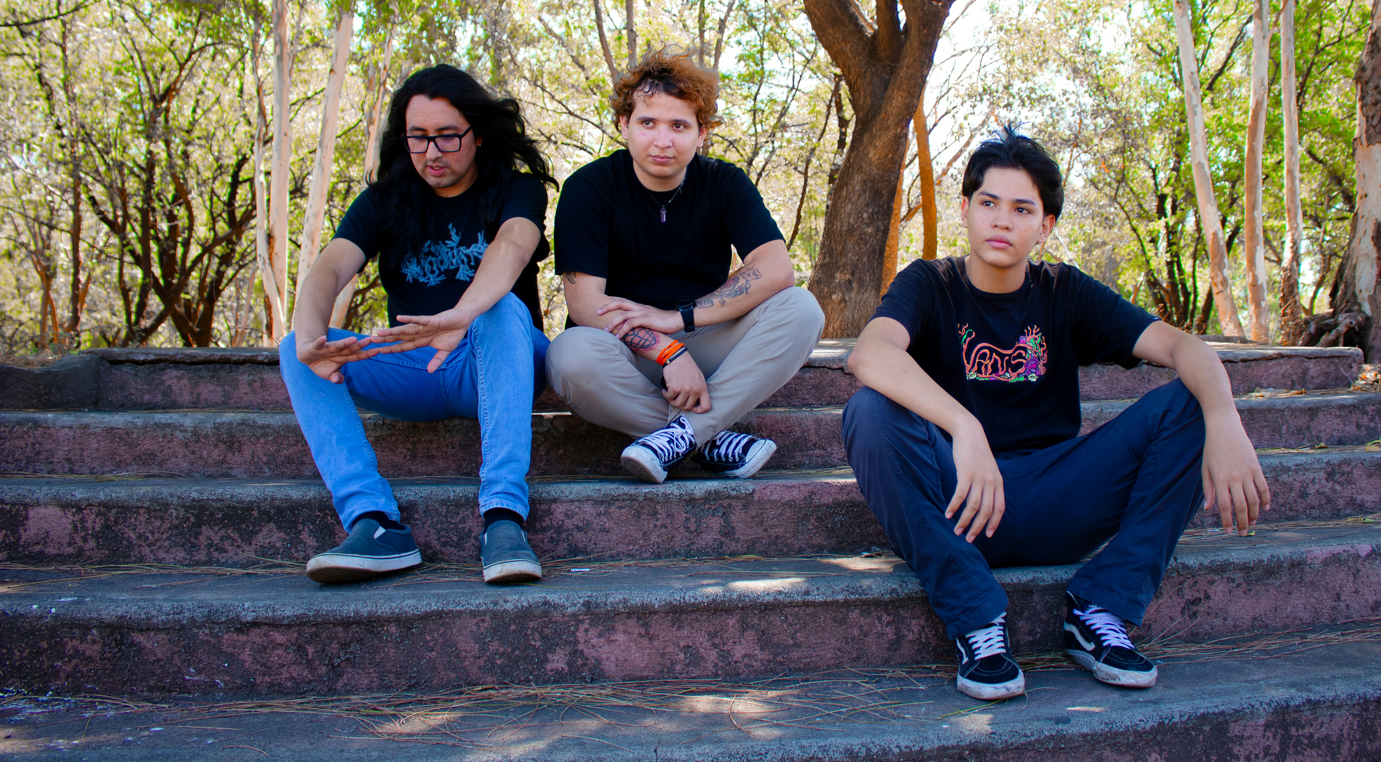 Three people sitting on outdoor stairs in custom t-shirts