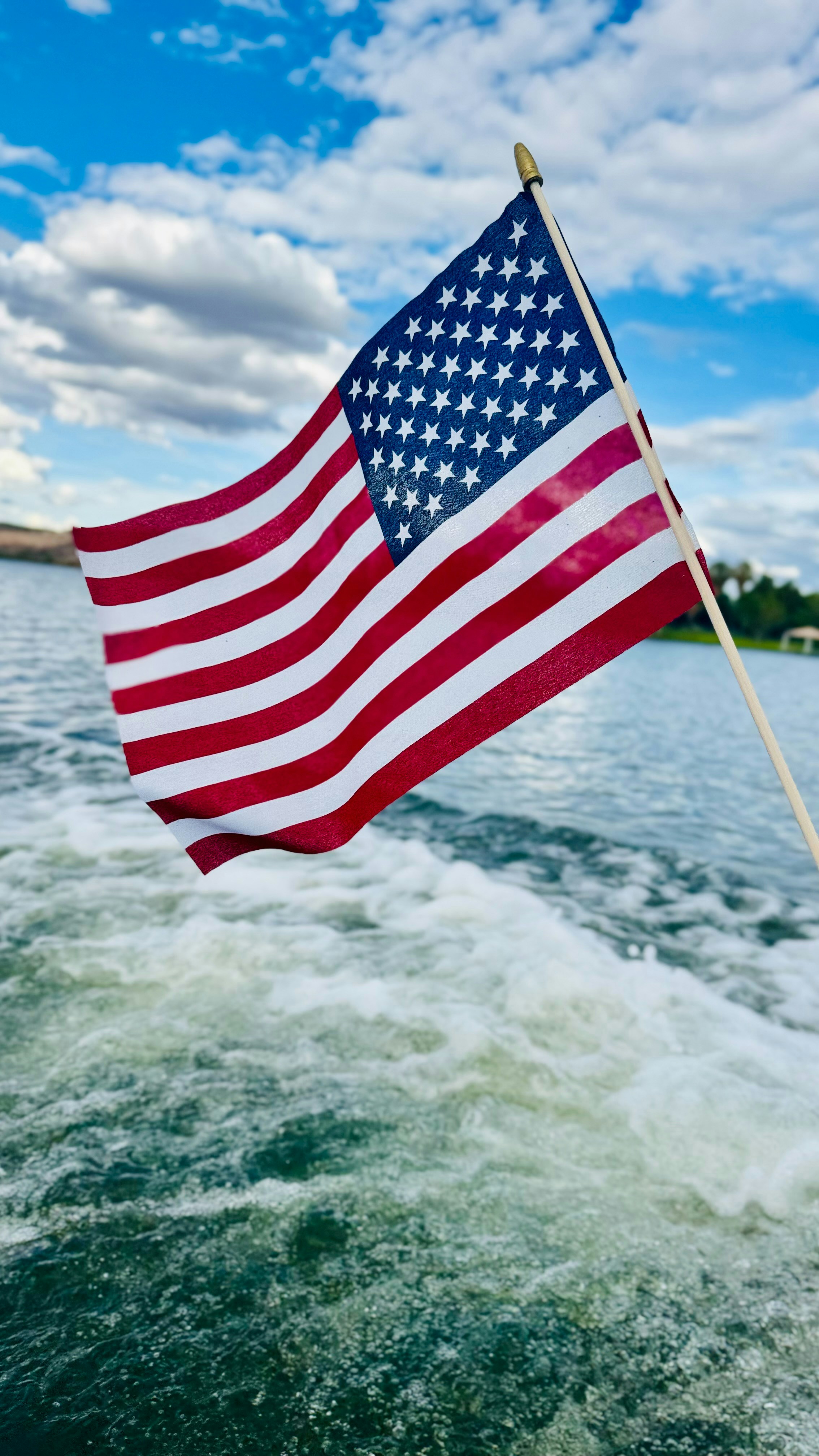 La bandera estadounidense ondea en un bote sobre el agua.