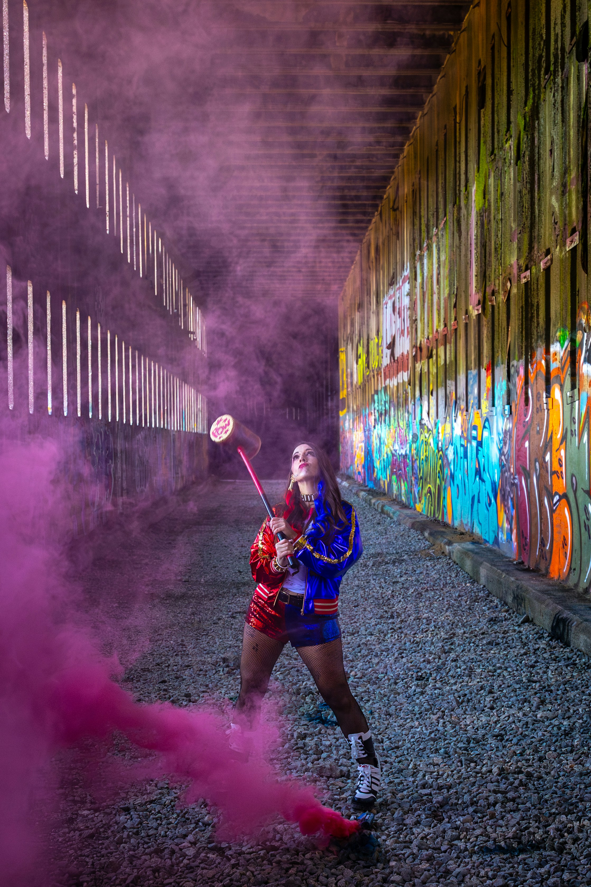 Woman with pink smoke bomb and colorful jacket