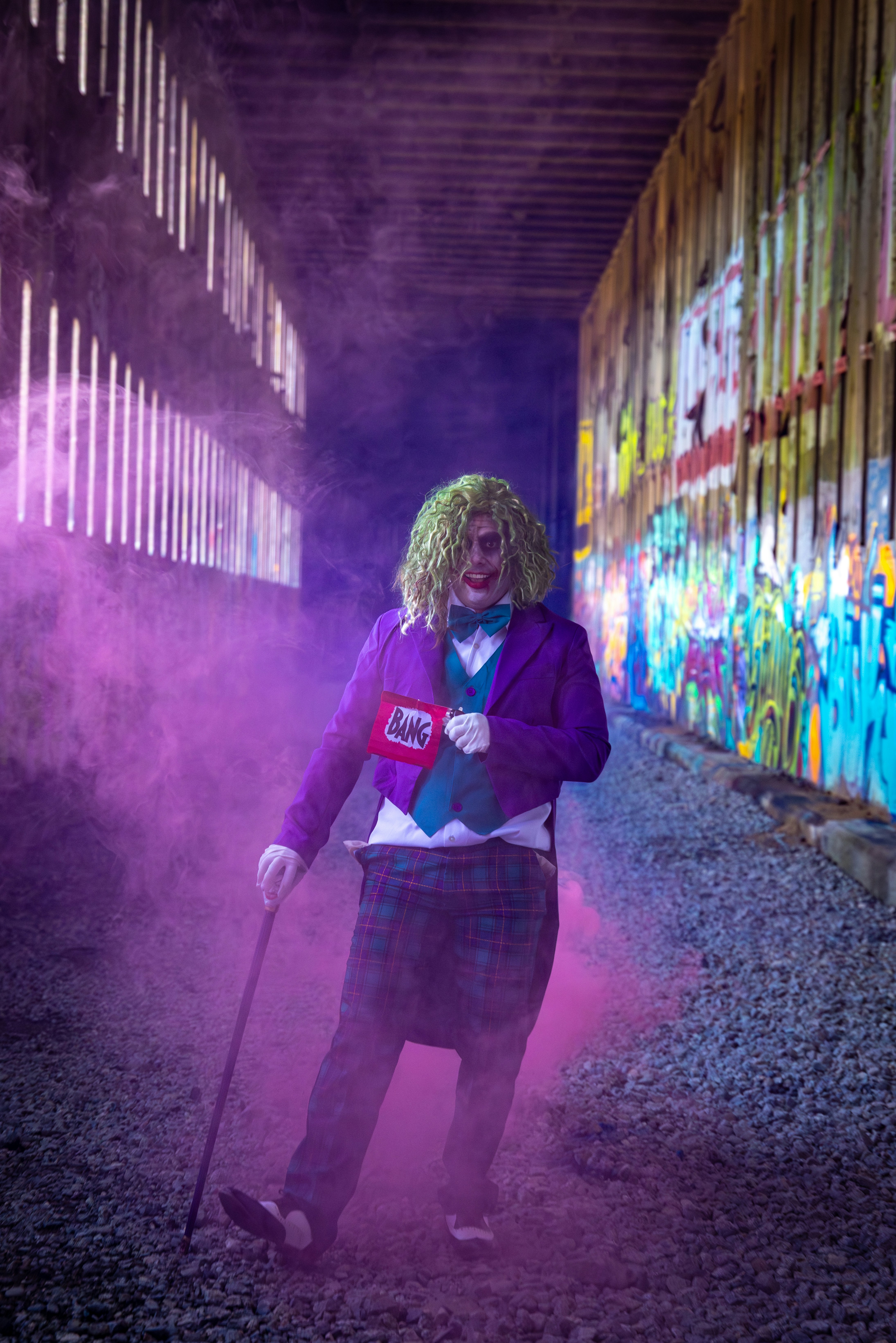 Cosplayer dalam kostum joker dengan bom asap merah muda