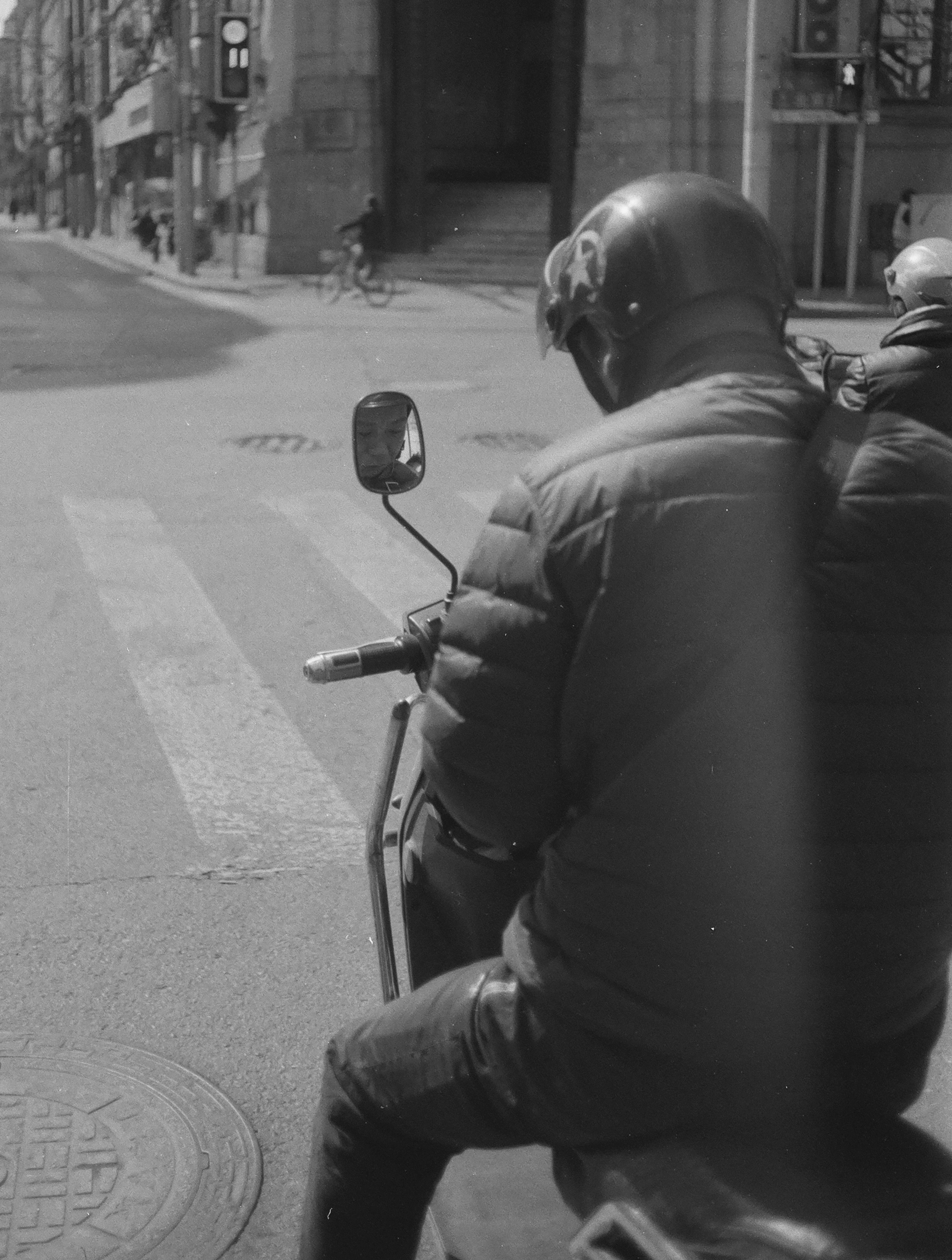 Man in helmet rides scooter on city street
