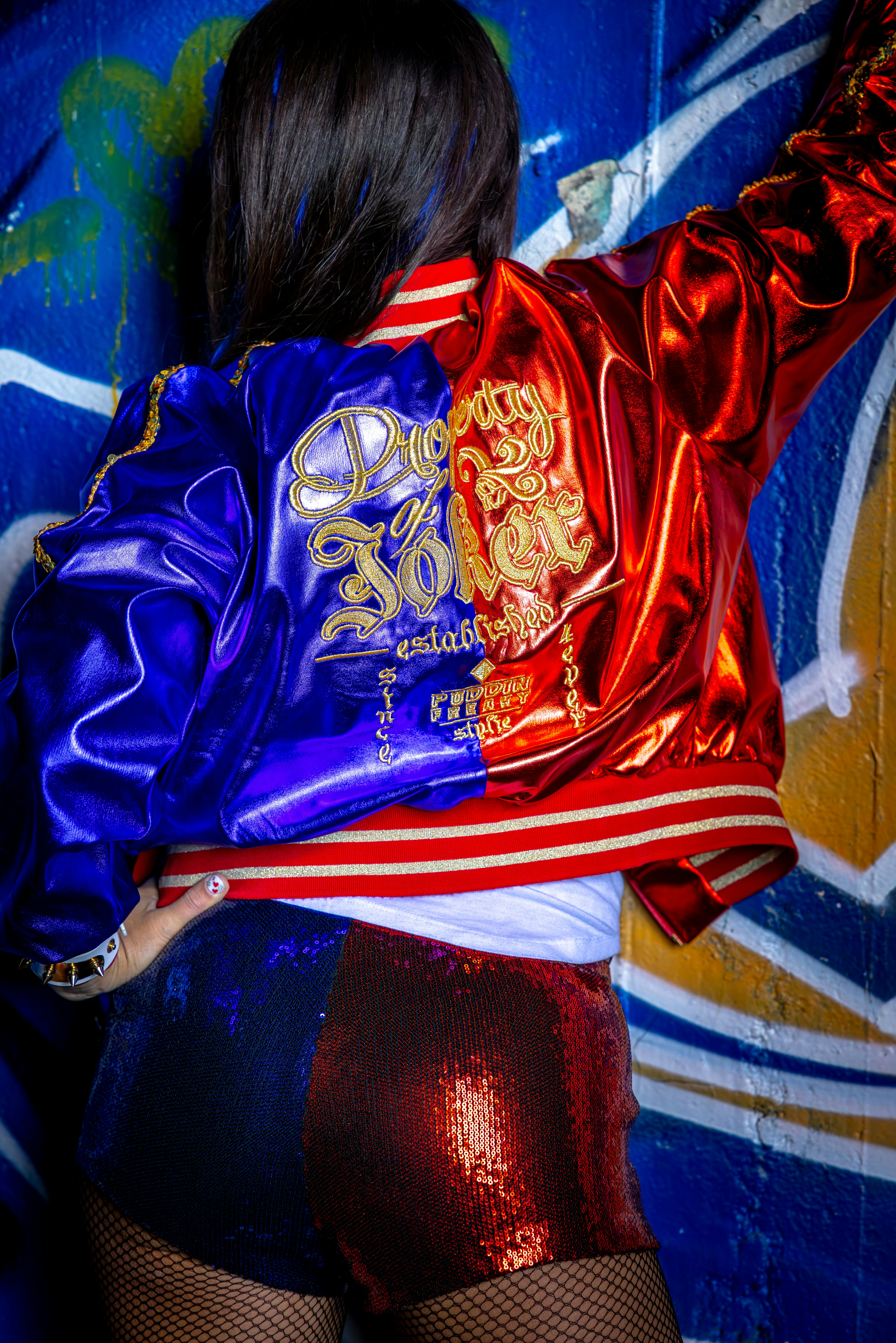 Wanita dengan jaket bomber dua warna dan celana pendek berpayet.