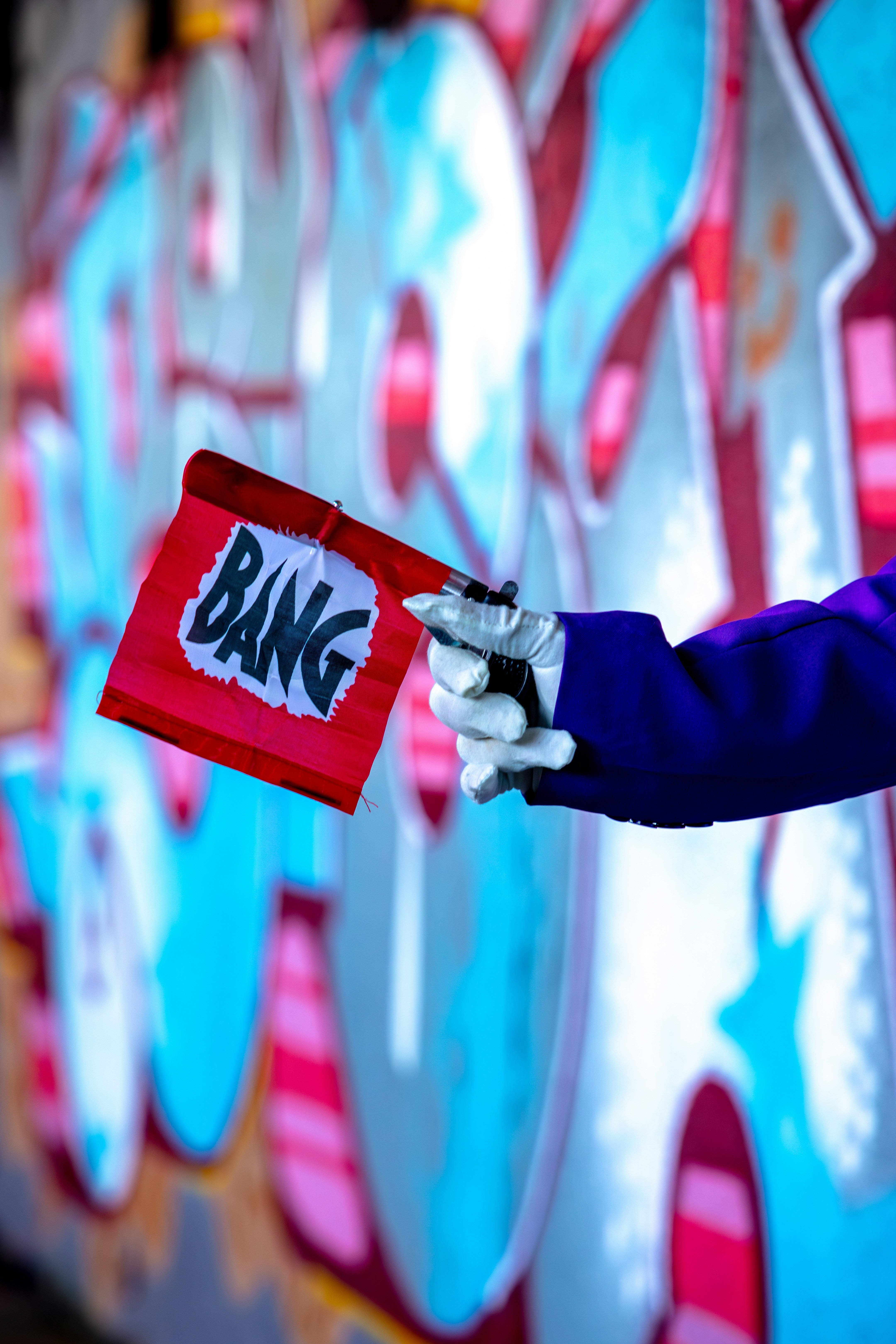 Tangan memegang bendera merah dengan kata bang.