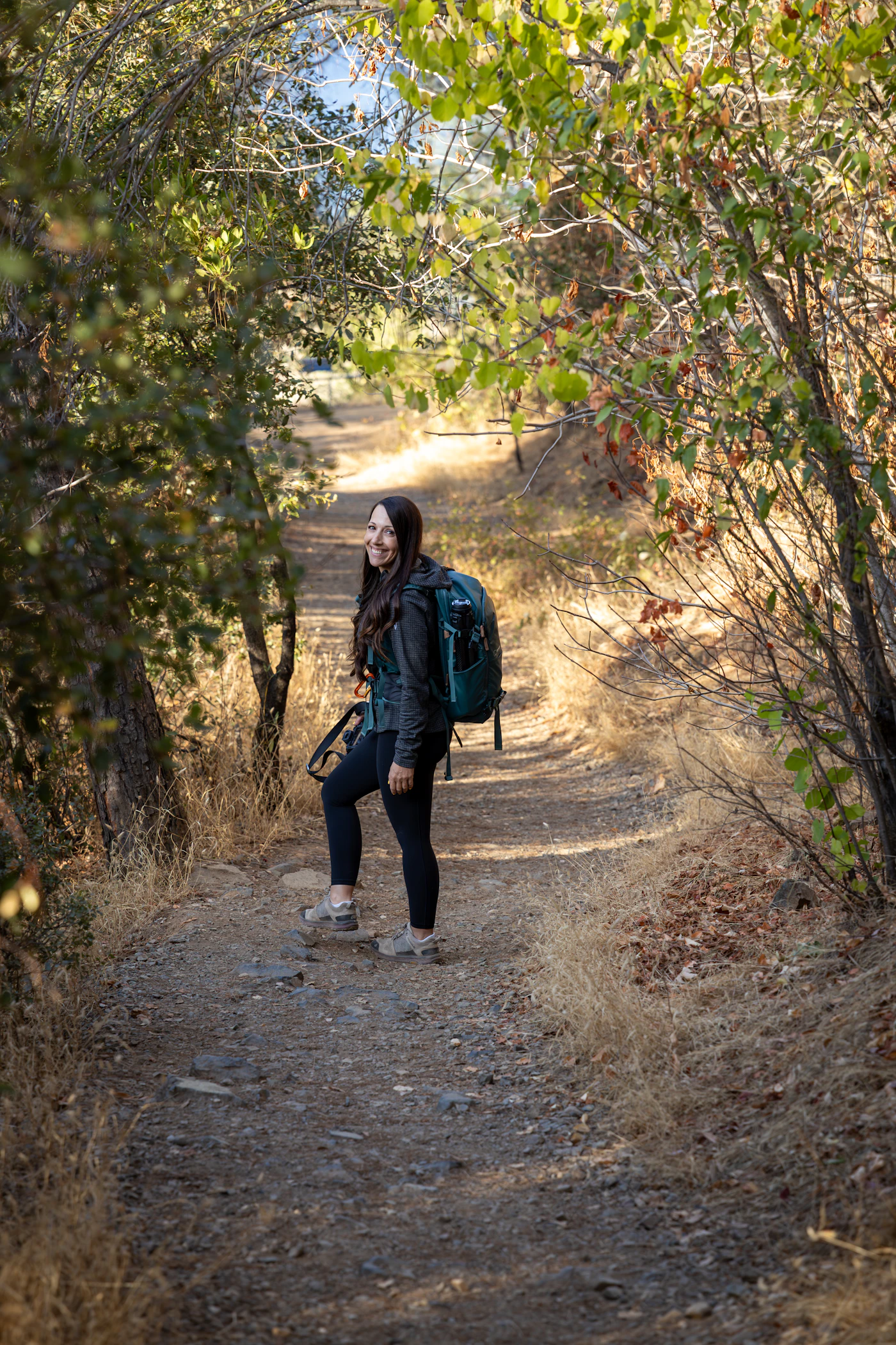 Woman hiking on a forest trail in outdoor performance clothing