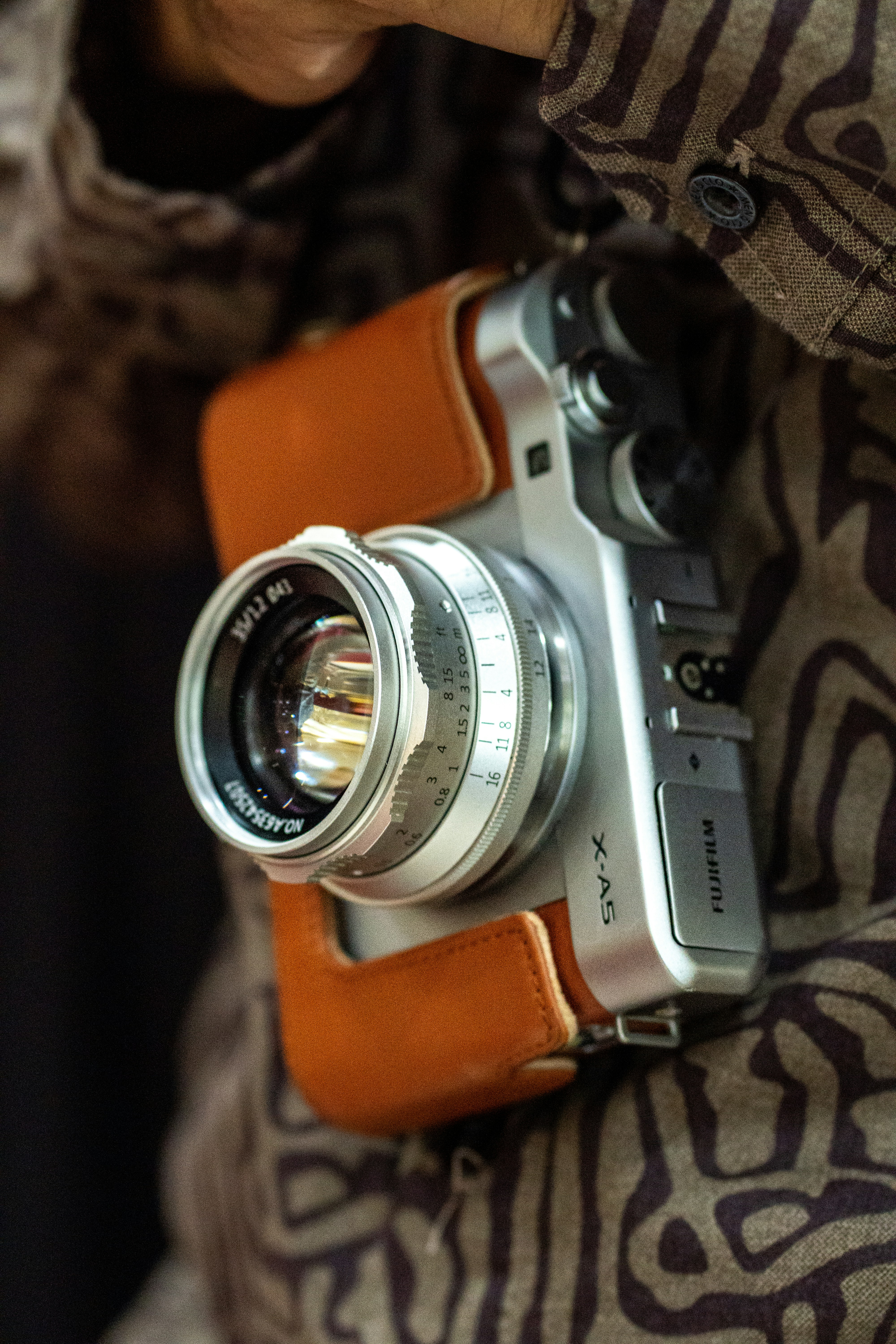 Silver fujifilm camera with leather case attached