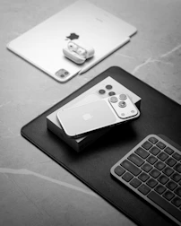 Apple devices including iphone, ipad, and keyboard.