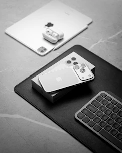 Apple devices including iphone, ipad, and keyboard.