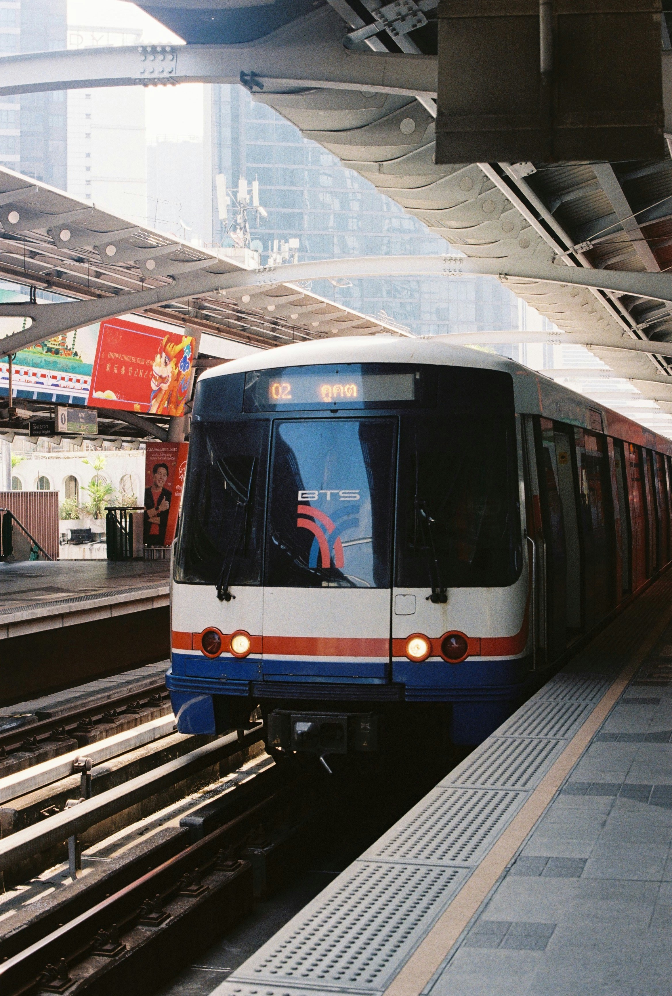 A modern train waits at a station platform.
