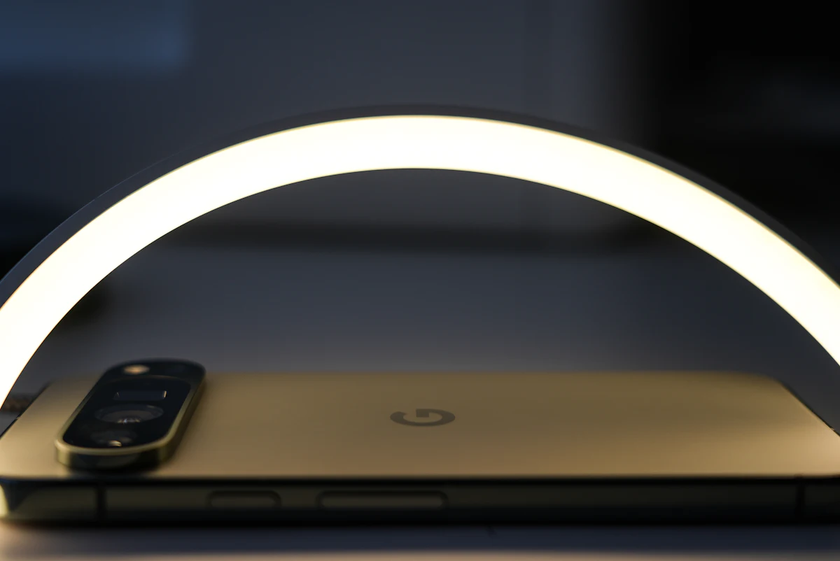 Ponsel dan lampu ring light tertata di atas meja sebagai stasiun produksi foto sederhana