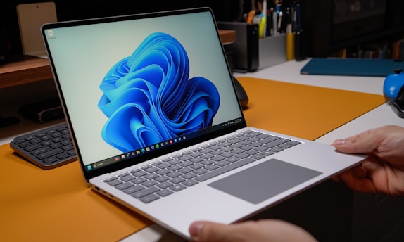 Hands holding a modern laptop with windows 11