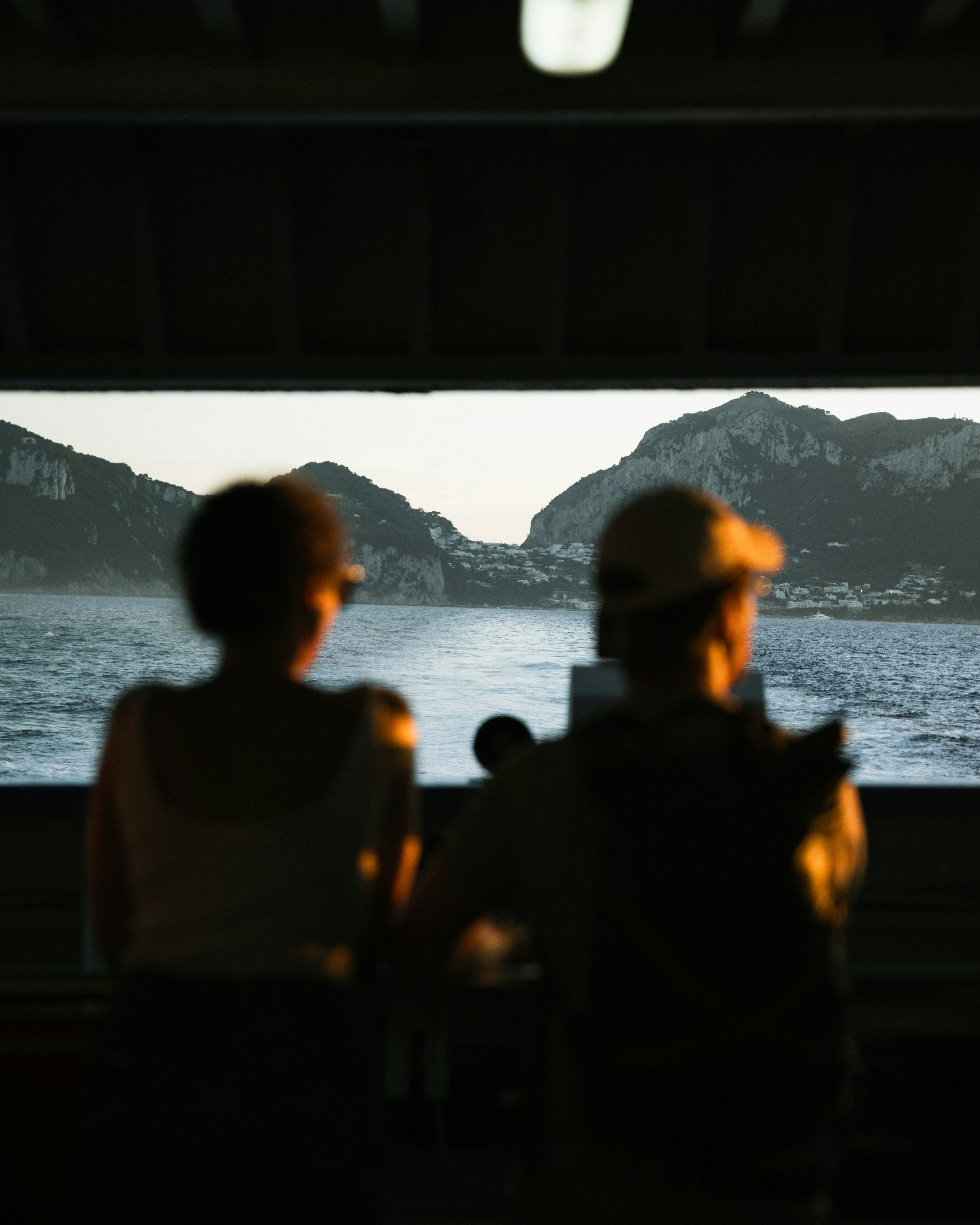 Two people watch islands across the water.