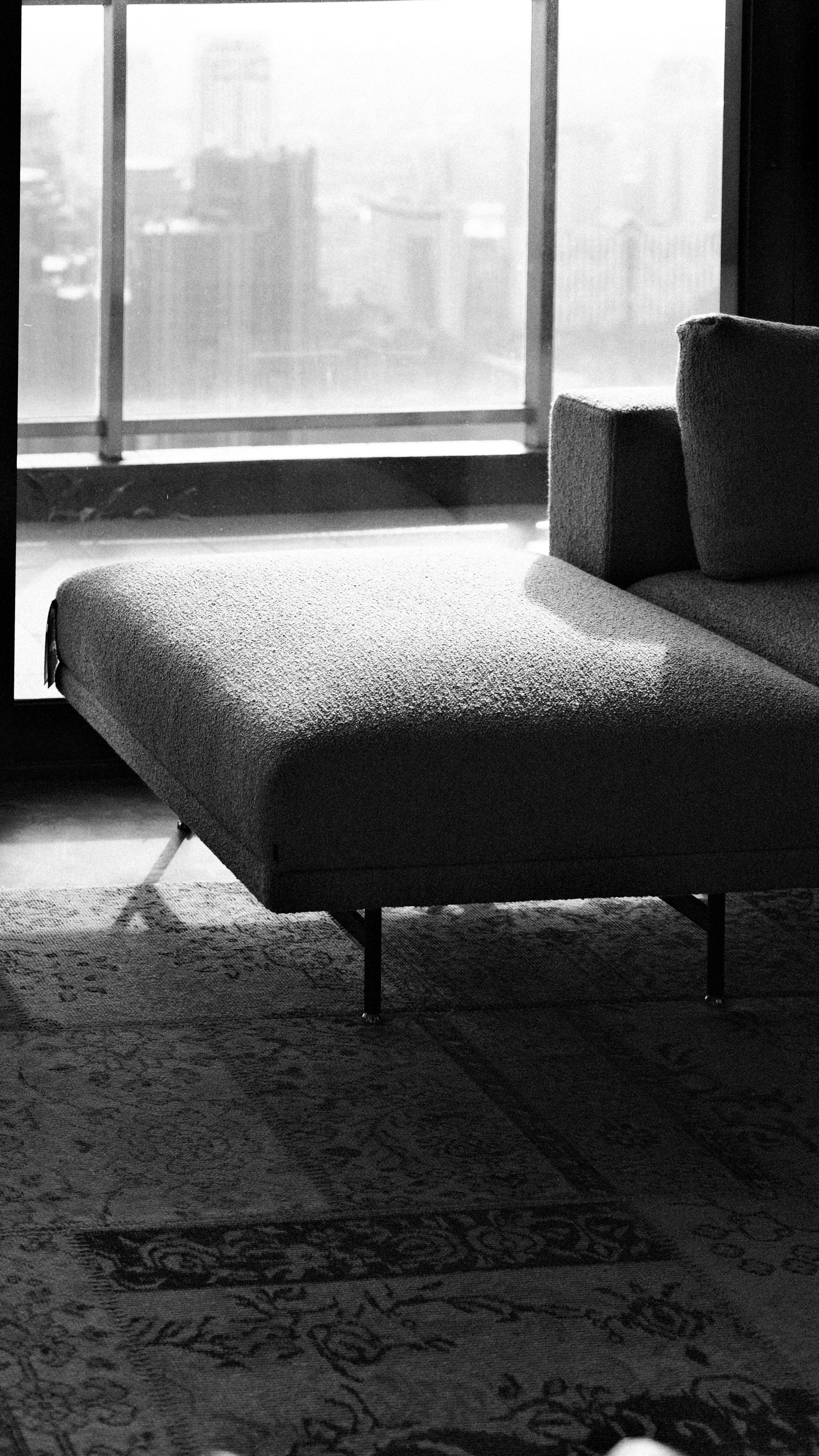 Modern sofa in front of a large window overlooking city