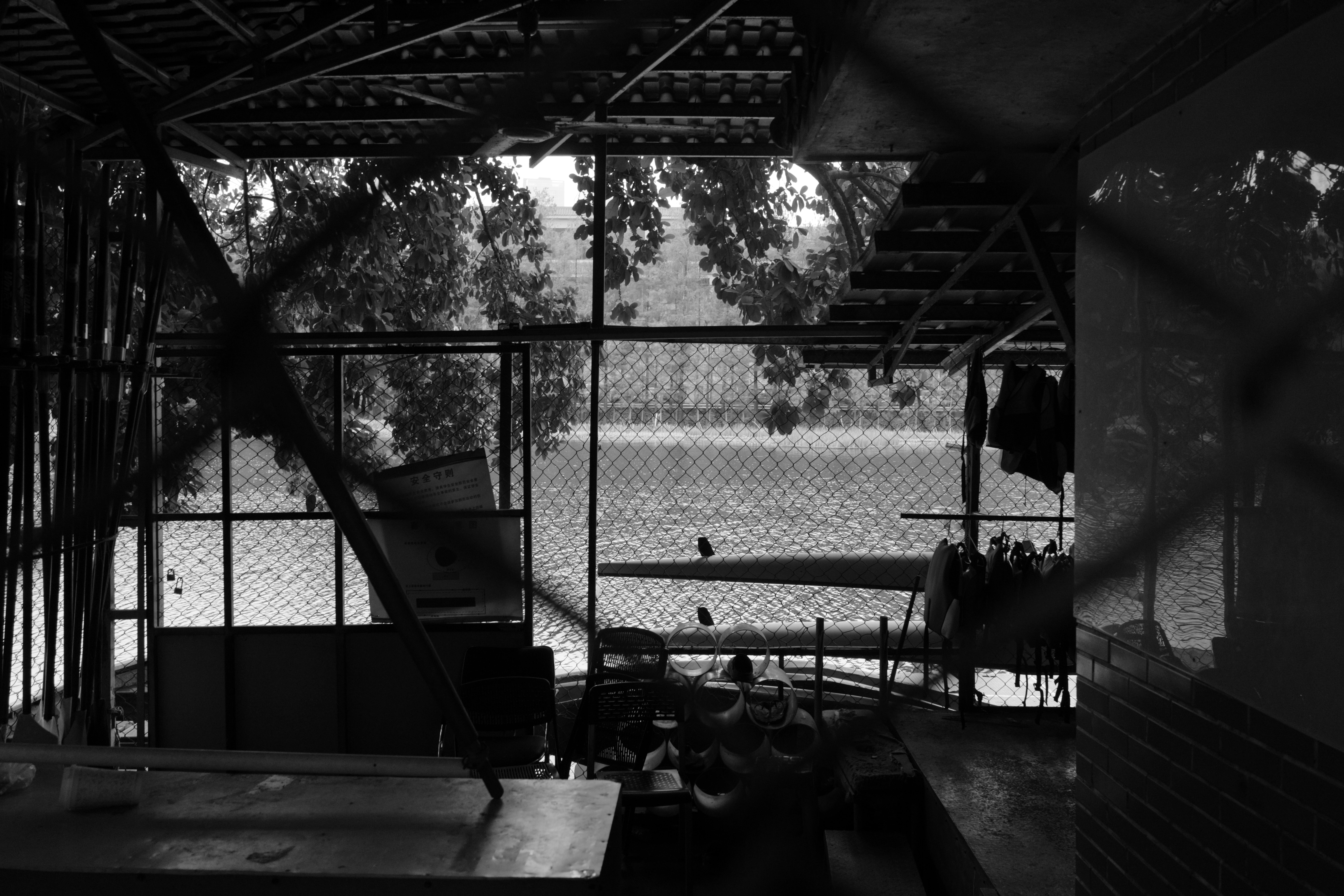Black and white view of a lake through a structure.