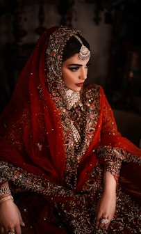 A bride in a red and gold ornate wedding dress.