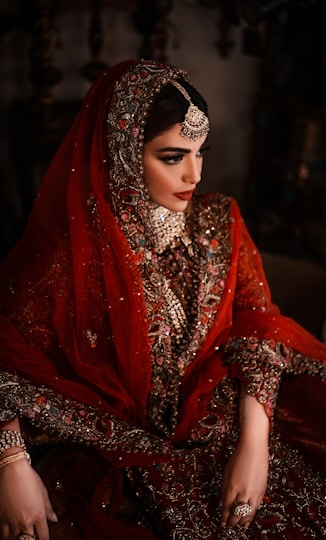 A bride in a red and gold ornate wedding dress.