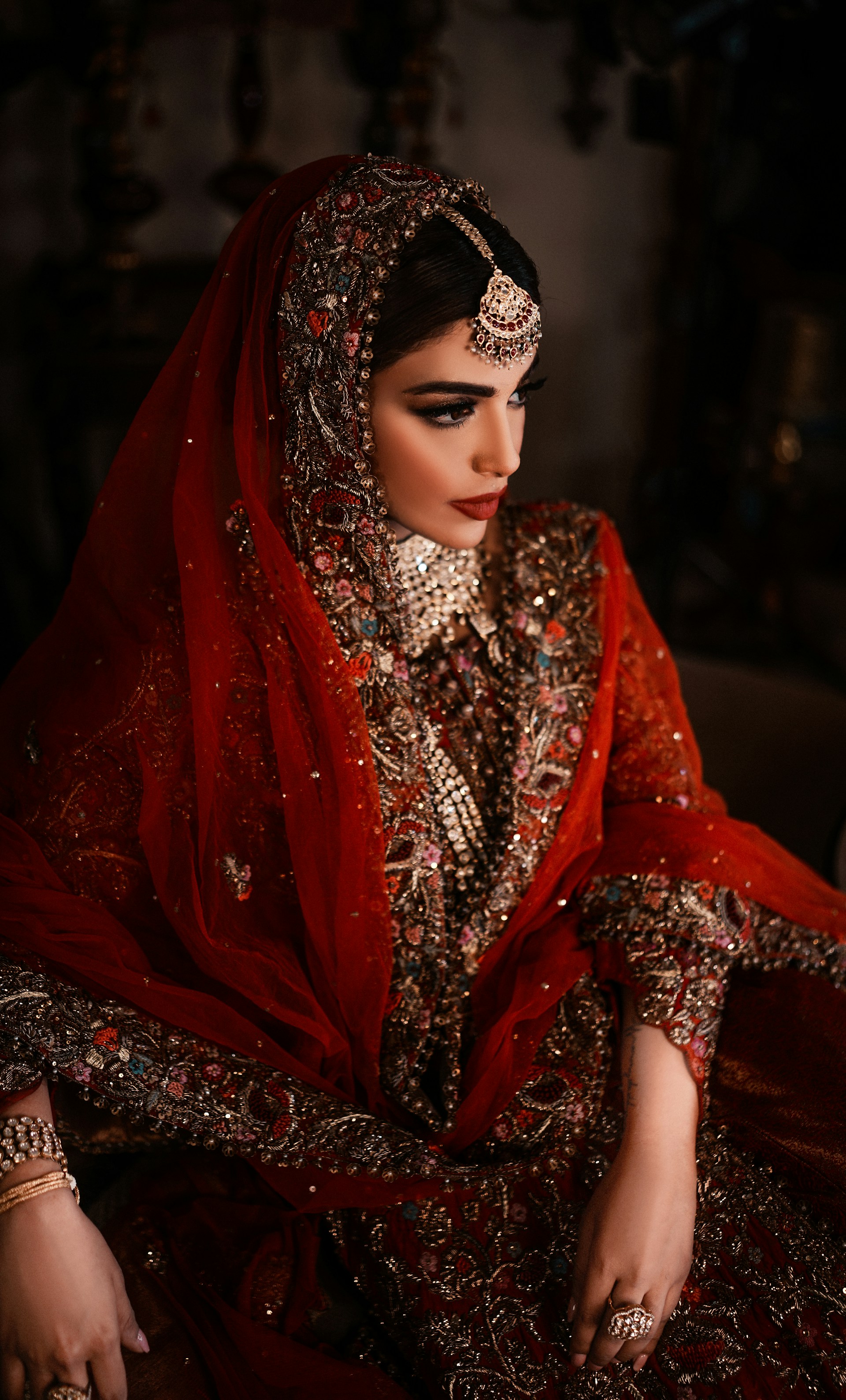 A bride in a red and gold ornate wedding dress.