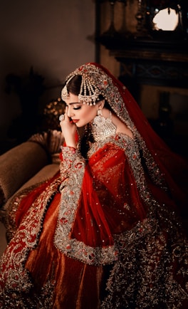 A bride in a red and silver ornate dress.