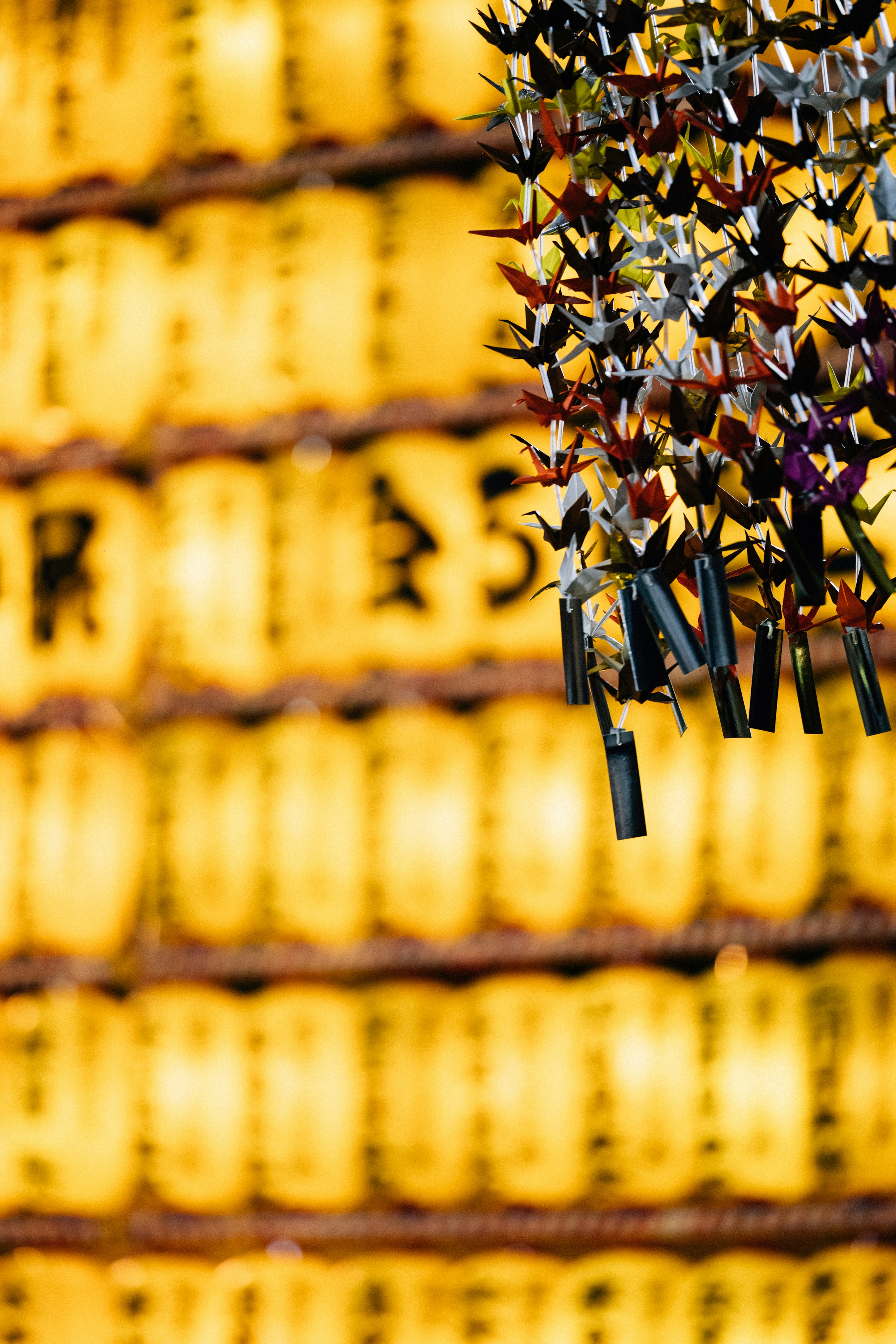 Guindastes de papel pendurados na frente de lanternas amarelas foto –  Imagem grátis sobre Viajar na Unsplash, image size:3000x4499