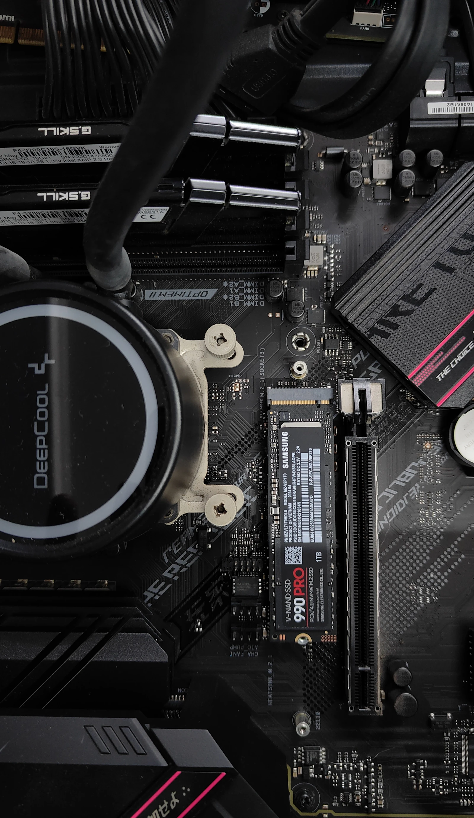 Computer motherboard with CPU cooler and an installed SSD showing NAND flash storage hardware