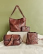 Four brown leather bags and wallets arranged artfully.
