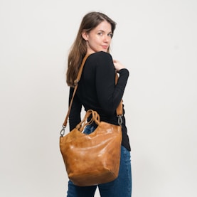 Woman in black shirt carrying a brown leather handbag