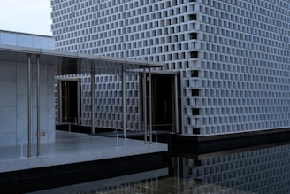 Modern building with reflective water and geometric facade