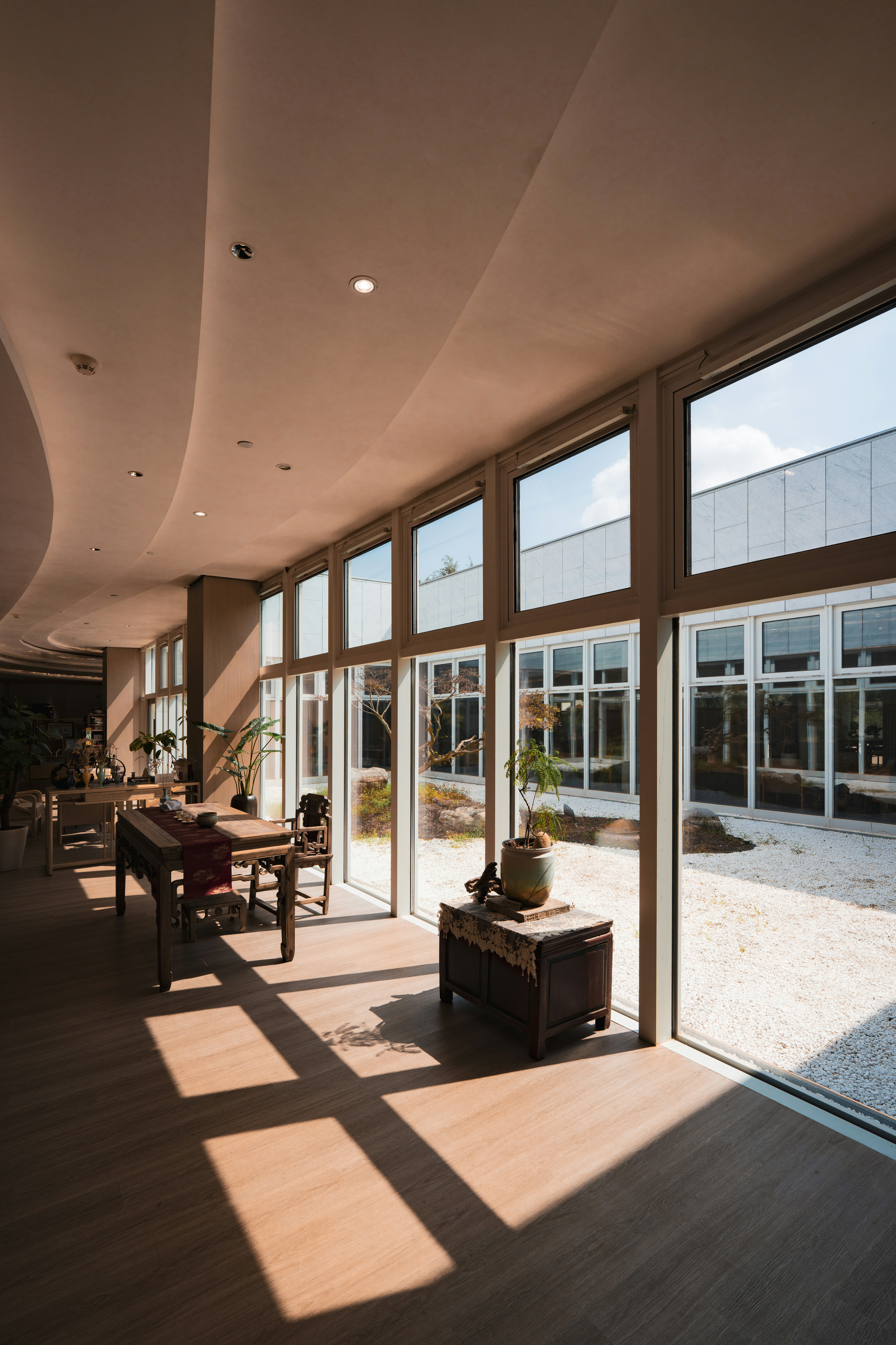 Modern interior with large windows overlooking a zen garden.